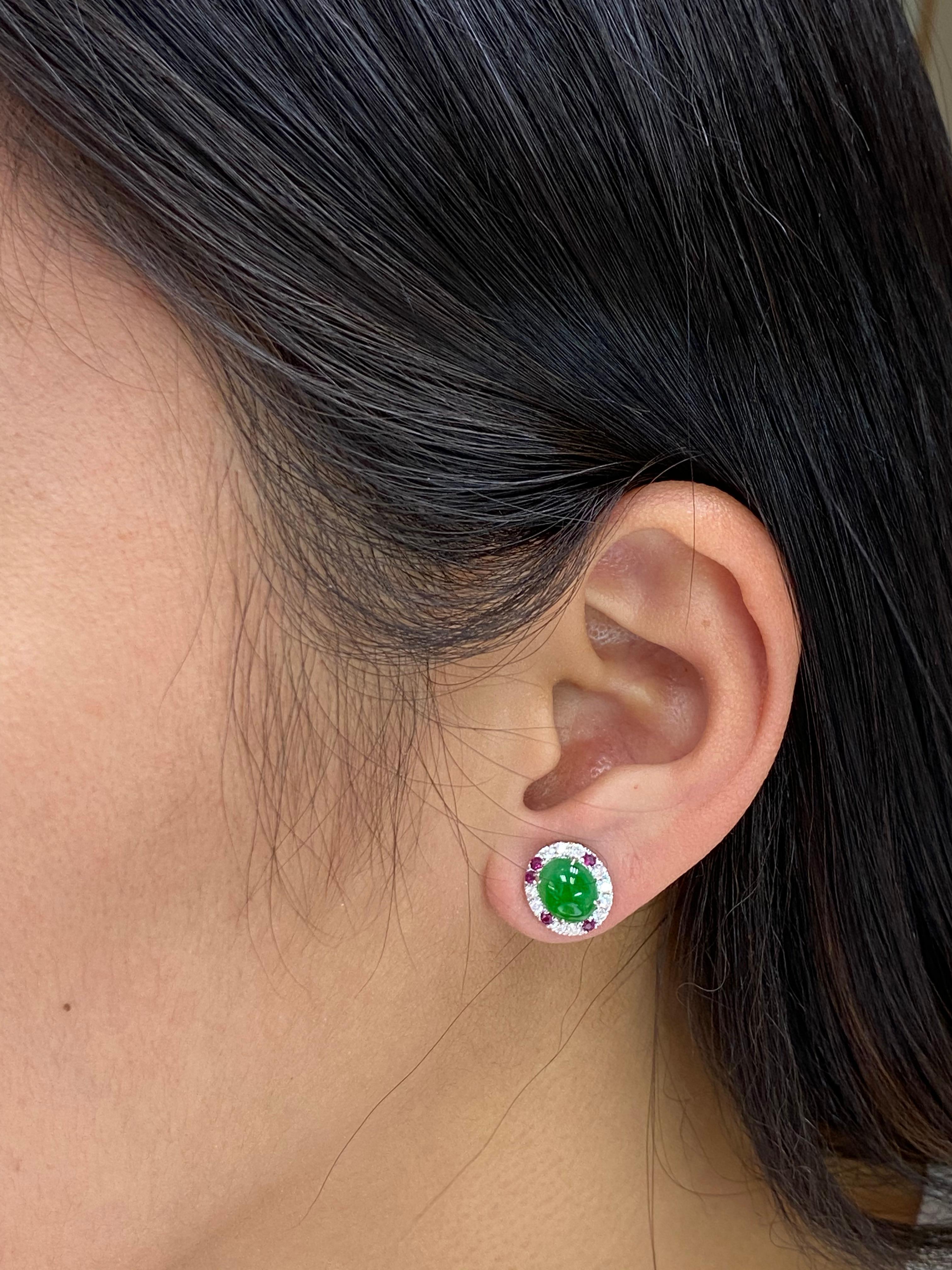 Here is a nice pair of apple green Jadeite Jade earrings. The earrings are about 11.8x 10.5mm each. The earrings are set in 18k white gold, Burma rubies and white diamonds. The 2 jade cabochons are 2.98Cts in total. There are 10 Burma rubies