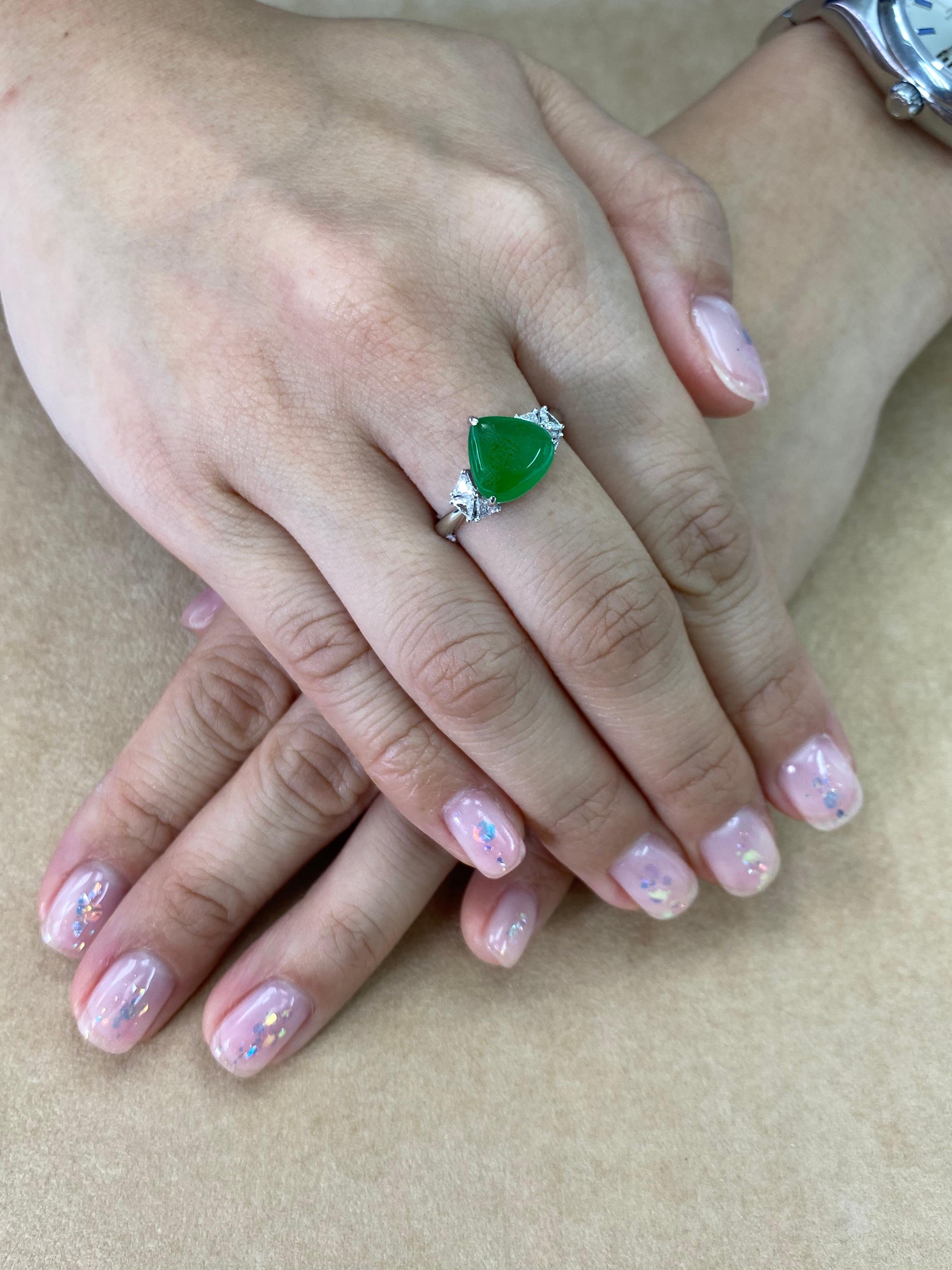 THIS JADE GLOWS! Here is an apple green Jade and diamond ring. It is certified by 2 labs as natural jadeite jade with no treatment or enhancement. The ring is set in 18k white gold and diamonds. There are 6 triangle shaped diamonds surrounding the