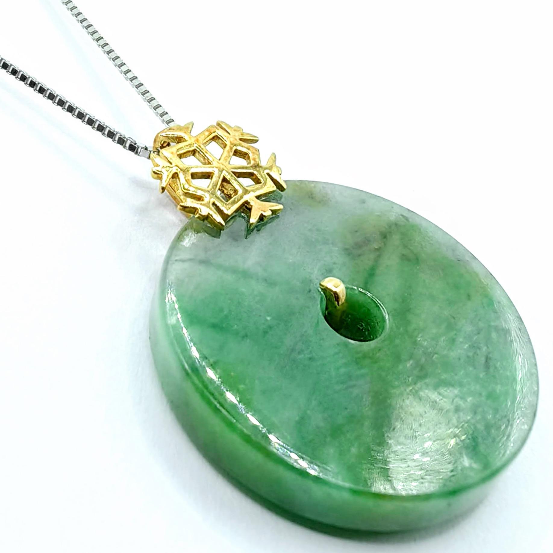 This magnificent pendant showcases a classic jade bi disc crafted from premium Old Mine Green jadeite, displaying beautiful natural color variations ranging from pale mint to deeper emerald green zones, with subtle marbling and translucent areas