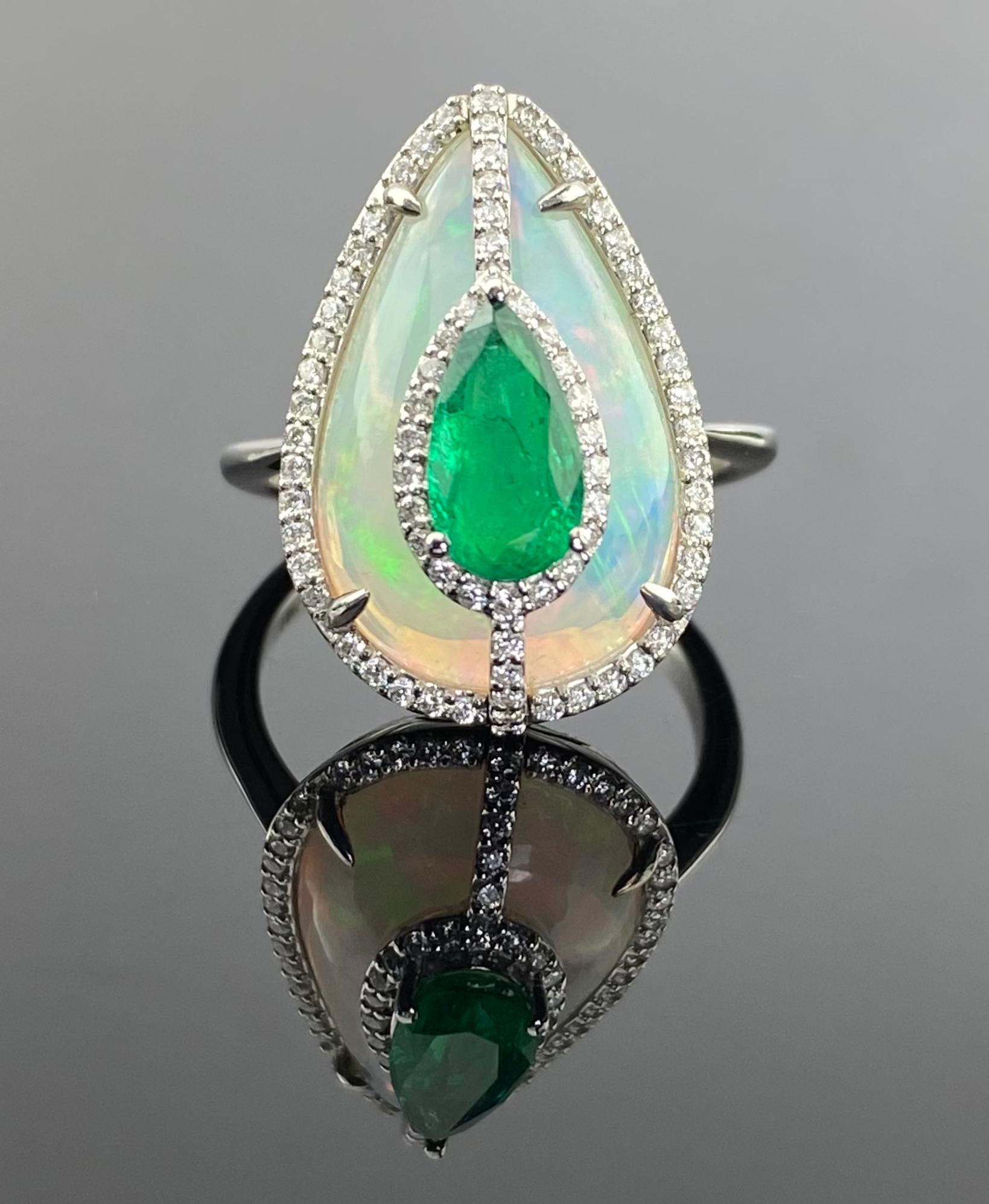 This exquisite pear-shaped ring is a stunning masterpiece that combines the brilliance of diamonds, the lush green allure of emeralds, and the captivating play of colors from opals. Currently sized at US 7, can be resized. We provide free shipping