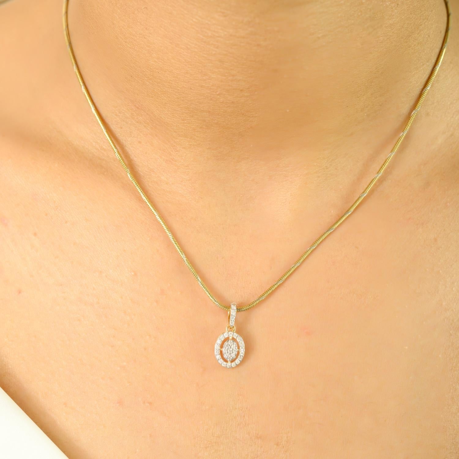 Delicato e abbagliante, questo pendente presenta un elegante design ovale aperto ornato da 0,19 carati di diamanti scintillanti. Realizzato in radioso oro giallo 18 carati, l'intricata incastonatura a pavé esalta la brillantezza di ogni diamante,