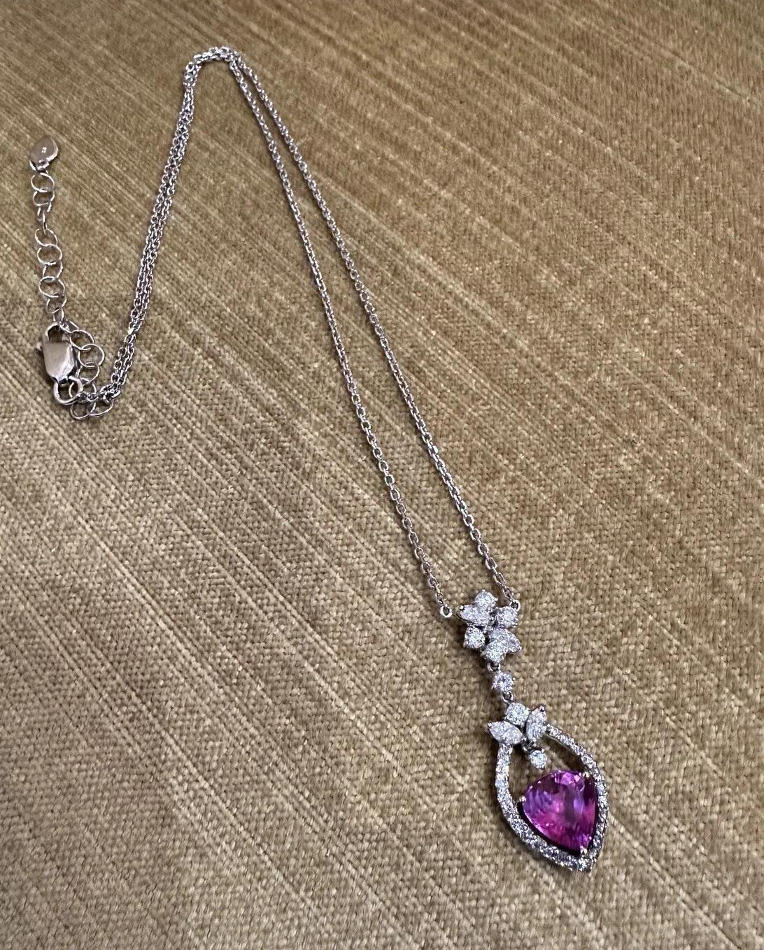 Certified Pink Sapphire and Diamond Pendant Necklace in 18k White Gold

Natural Pink Sapphire and Diamond Necklace features a Purplish-Pink Modified Heart Mixed Cut Sapphire in the center of the pendant surrounded by Round and Marquise Diamonds, all