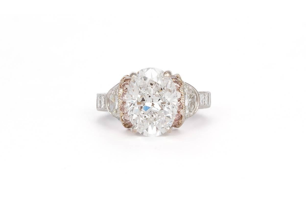 We are pleased to offer this Certified Platinum & Rose Gold Oval Diamond Engagement Ring 5.56ctw. This beautiful ring features an EGL certified 4.31ct E/SI2 Oval Brilliant cut center diamond accented by 0.45ctw F-G/VS2 half moon cut diamonds,