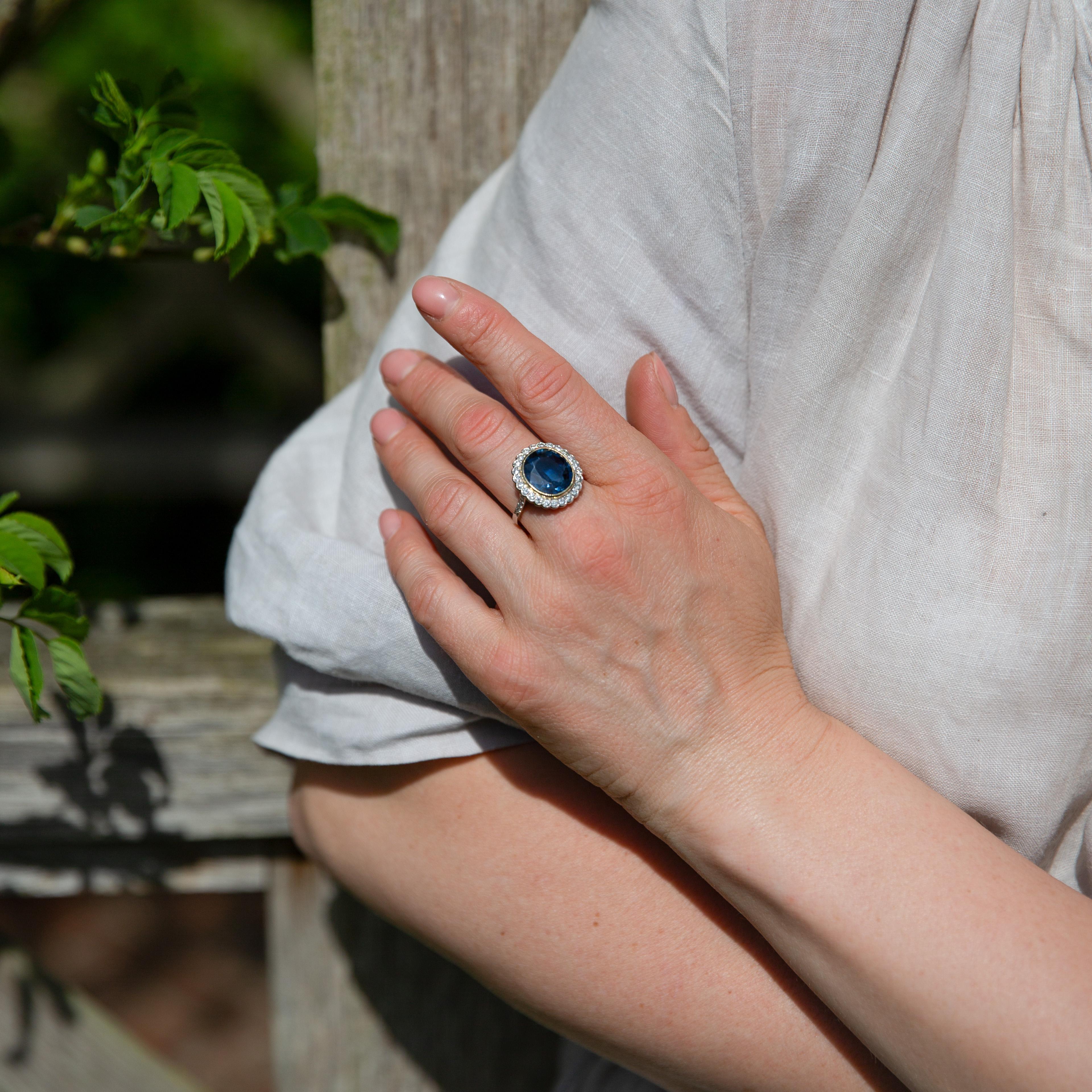 Anello a grappolo in platino certificato con zaffiro blu non riscaldato da 6 carati e diamanti.

Un anello a grappolo elegante e senza tempo realizzato in platino, che mette in mostra uno zaffiro naturale non riscaldato certificato del peso di circa