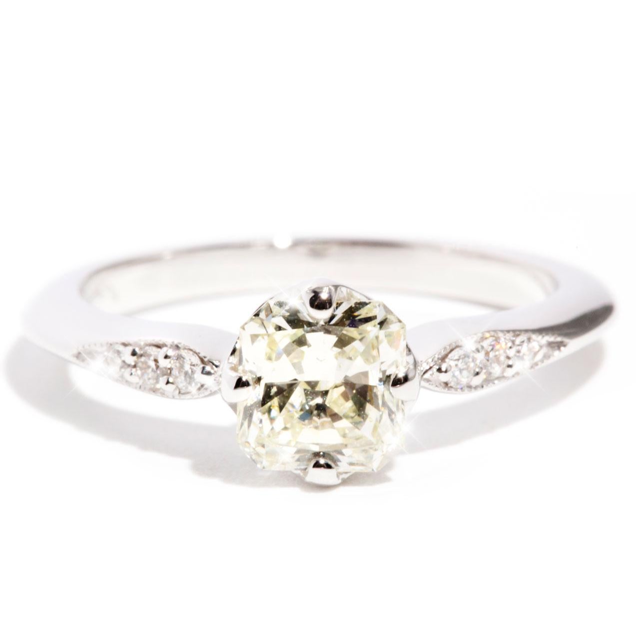 Carefully crafted in 18 carat white gold is this vintage inspired diamond ring featuring a sparkling 0.90 carat certified radiant cut diamond, and embellished with petite round brilliant cut diamonds gracefully flowing down the band.  We have named