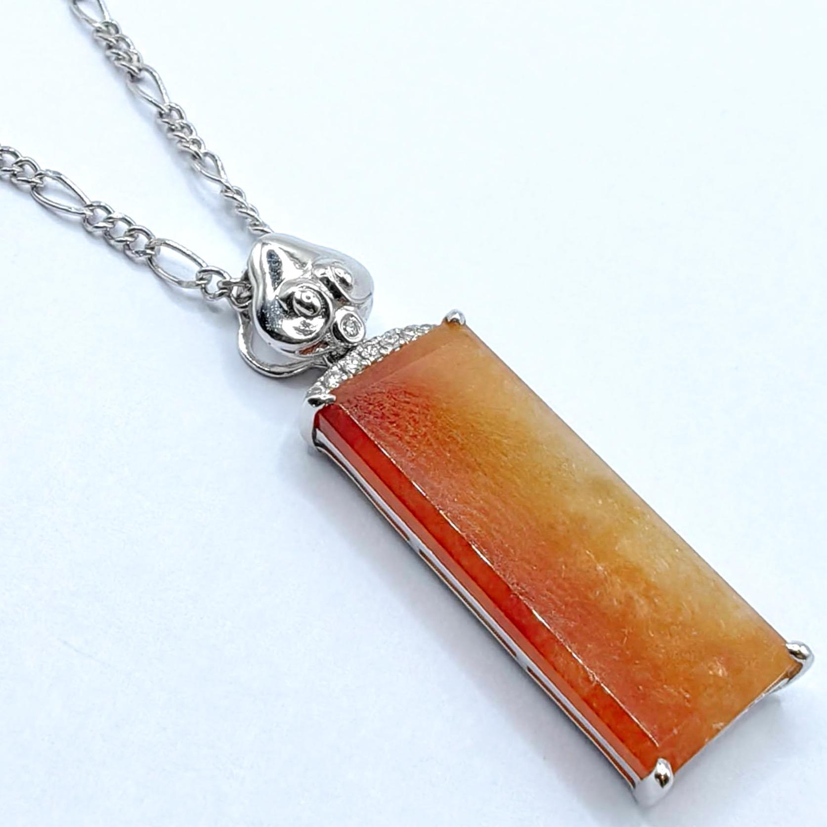 Entdecken Sie die warme Eleganz dieses Friedensanhängers aus rotem Jadeit, der auch als 