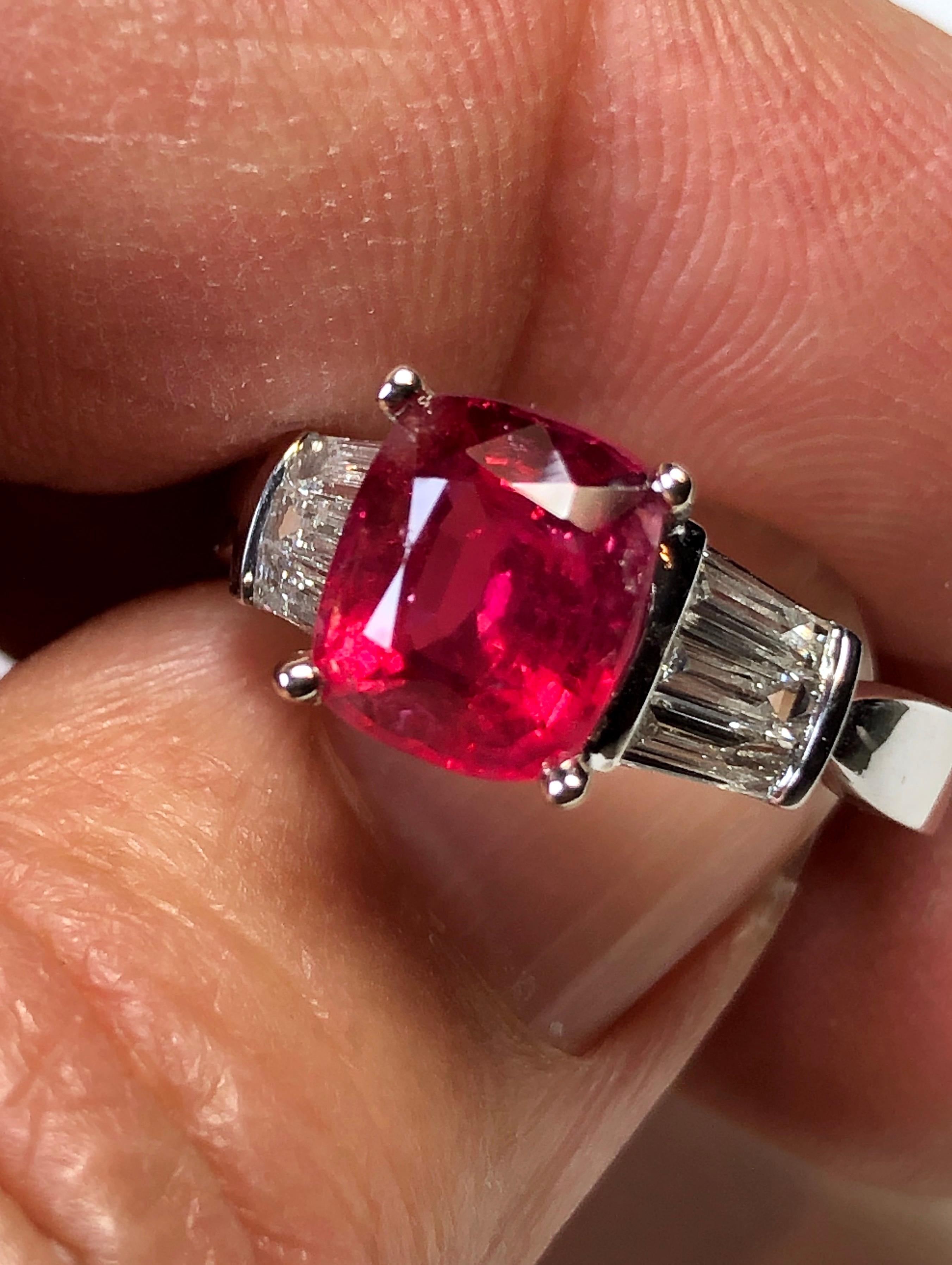 Stunning and classic natural untreated cushion-cut vivid red Mahenge Spinel weighing 2.21 carats GFCO certified. Accented by 6 baguette diamonds weighing 0.57ct, G in color, and VS in clarity. Solid 18K white gold. 
The ring size is 6.5. 
Weighs 4.6