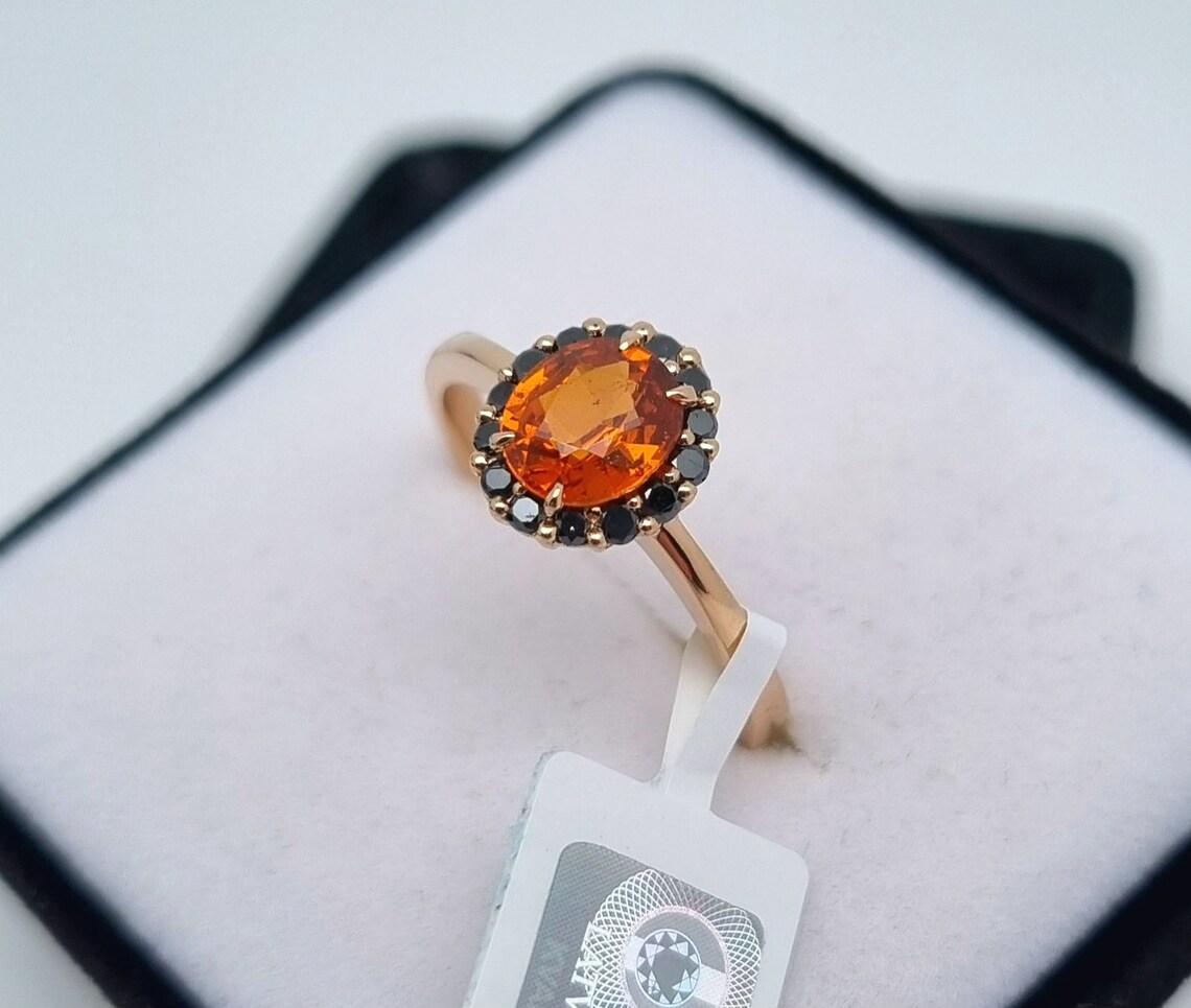 Natural Spessartine and Black Diamonds gems
Solid 14 Karat Rose Gold Ring

Laboratory full certificate
Main Stone: Spessartine
Main Stone Creation: Natural
Main Stone Color: Orange
Main Stone Origin: Africa
Main stone size: 6.8x5.8mm
Ring Size: 8US