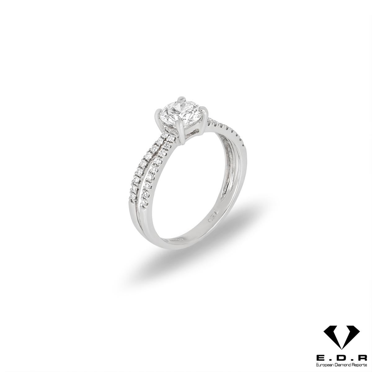 A stunning 18k white gold diamond ring. The ring is set to the centre with a round brilliant cut diamond weighing 0.76ct, E colour and VS1 clarity. The diamond is accentuated by a split shank consisting of pave set round brilliant cut diamonds
