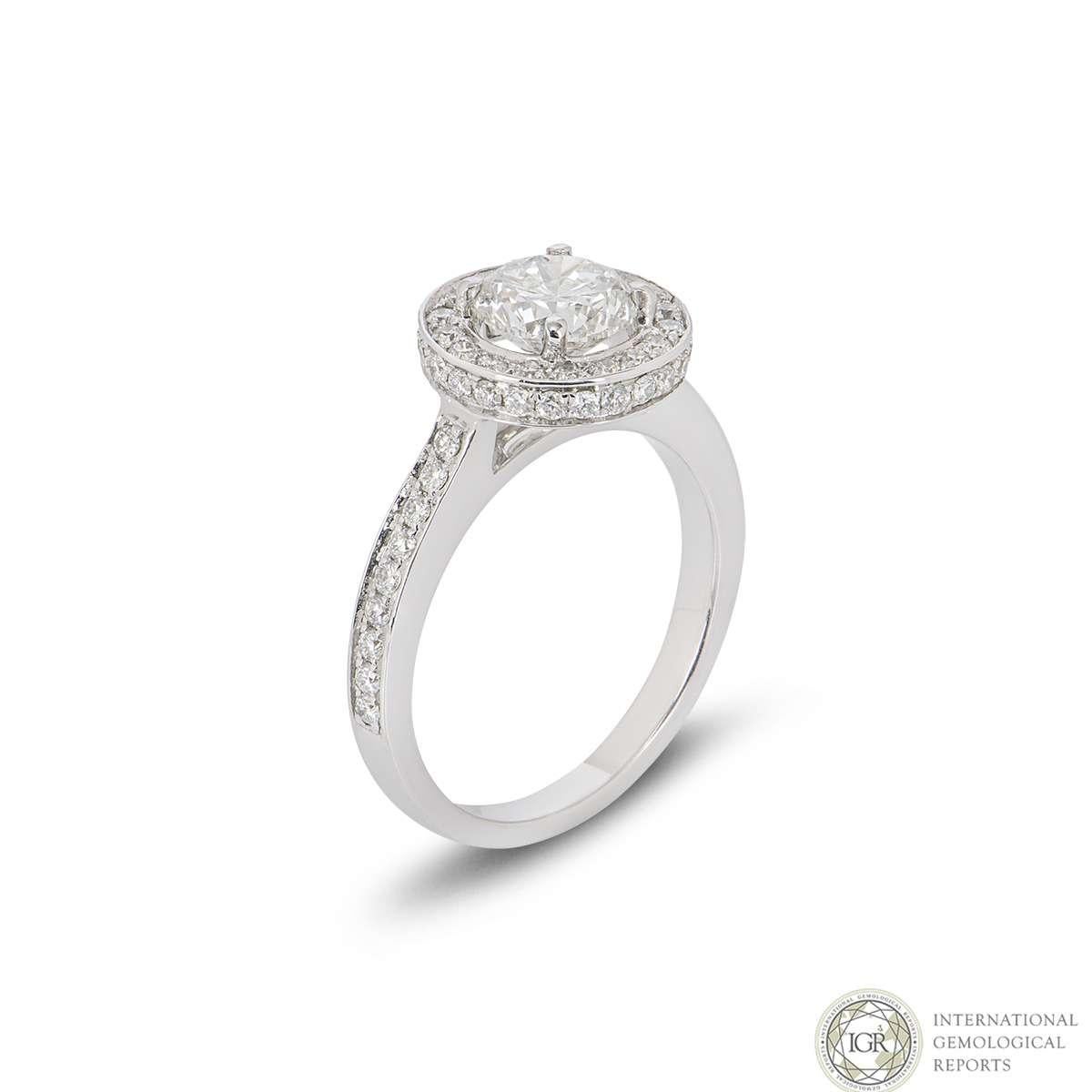 An intricate 18k white gold round brilliant cut diamond halo ring. The ring is set to the centre with a 1.07ct round brilliant cut diamond, H in colour and SI3 in clarity set within in a classic four claw setting. Complementing the centre stone is a