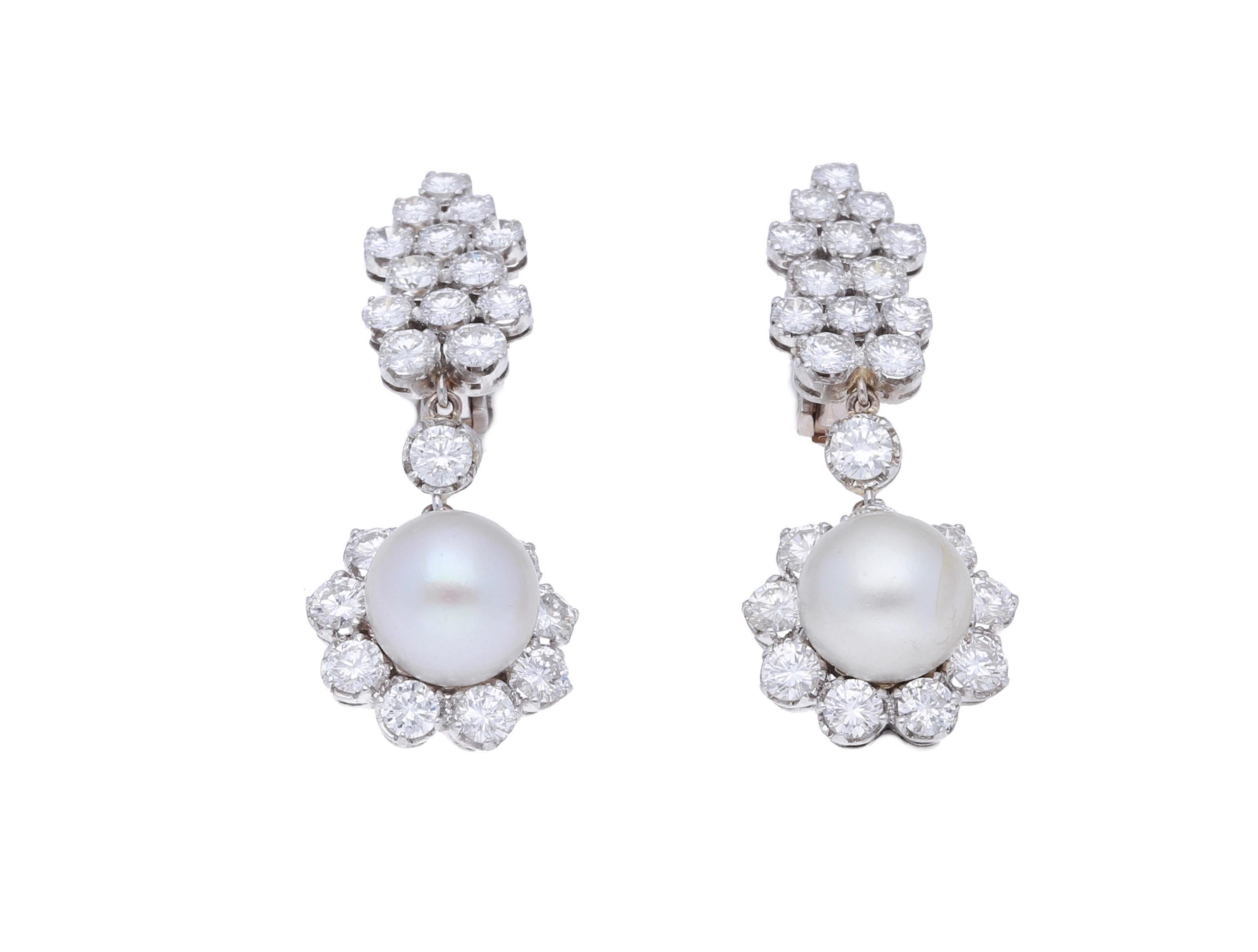 18 kt. white gold earrings with 7.00 carat of round-cut diamonds and 2 natural saltwater pearls.
The pearls are approximately 9.77 x 7.35 mm., are partially drilled and have spherical shape.
Those earrings are hand-made in Italy from 1980 ca.
