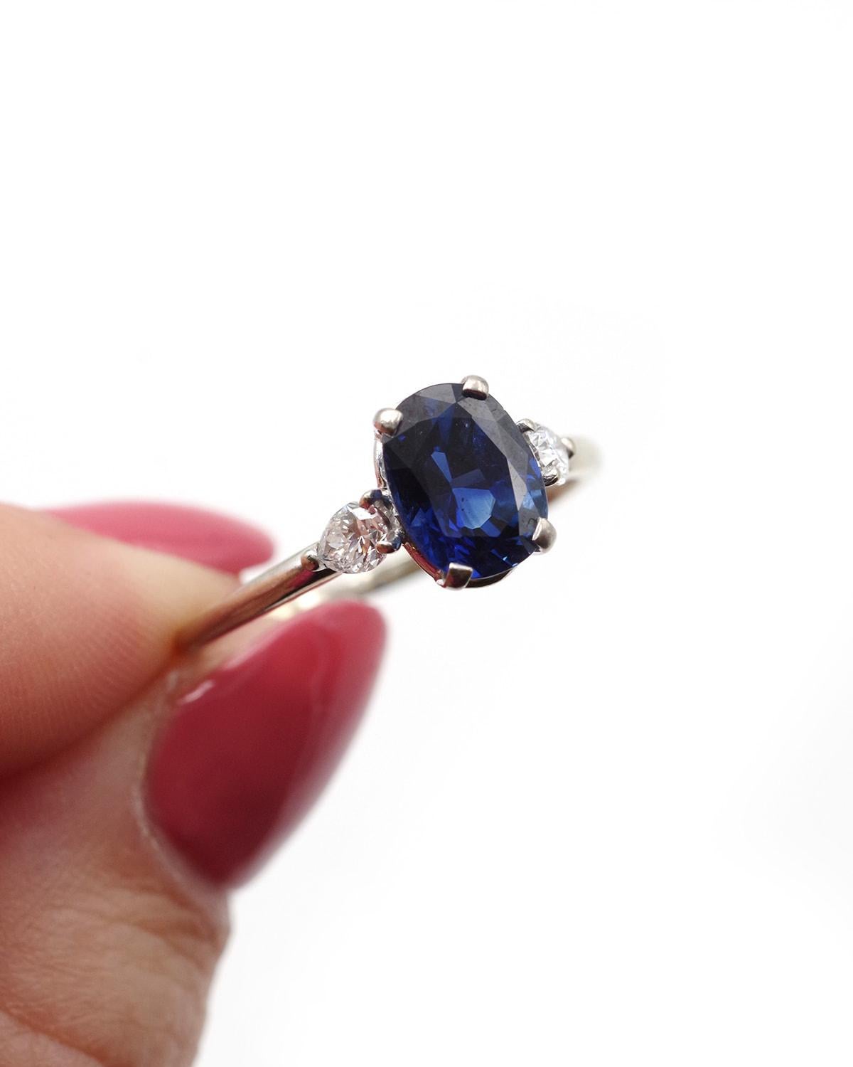 Anello con zaffiro e diamante da 2,26 carati in oro bianco 18 carati. Anello con zaffiro ovale da 2,26 carati, affiancato da due diamanti taglio pera da 0,18 carati. Lo zaffiro naturale ha un bellissimo colore blu intenso che può essere definito