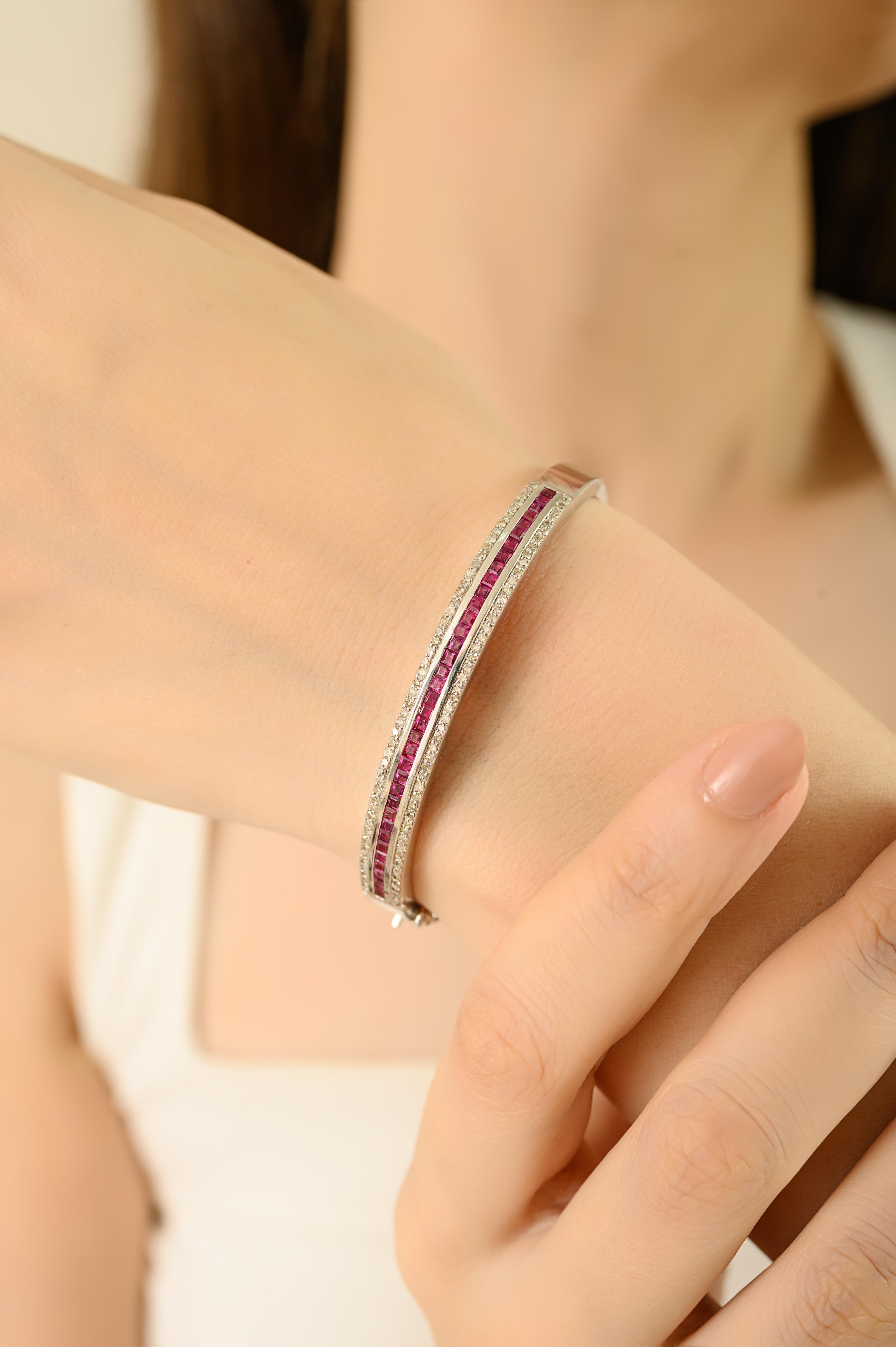 Elegante brazalete de plata de ley 925 con 1,75 quilates de rubíes naturales engastados en canal en el centro, enmarcados por 1 quilate de brillantes diamantes. Los rubíes, conocidos como la piedra de la pasión, la vitalidad y el amor, hacen de esta