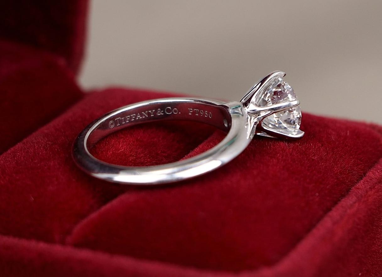 Questo anello di fidanzamento in platino certificato Tiffany & Co. presenta uno splendido diamante tondo brillante da 1,70 carati di qualità eccezionale. Il diamante centrale è classificato di colore D, il grado più alto della scala cromatica, e