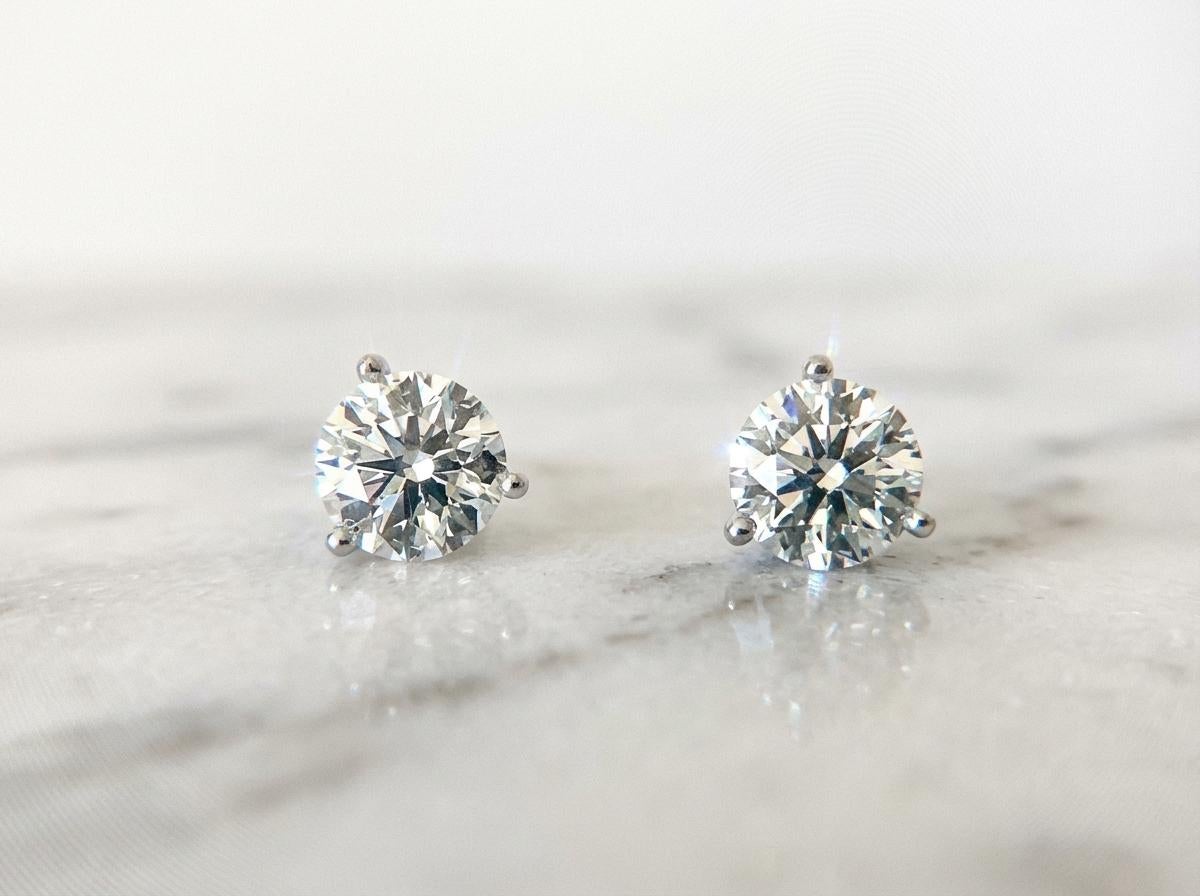 Questi orecchini con diamanti certificati di Tiffany & Co. presentano due eccezionali diamanti tondi taglio brillante, ciascuno del peso di 1,00 carati, incastonati in una classica montatura in platino che evidenzia la rinomata precisione e maestria