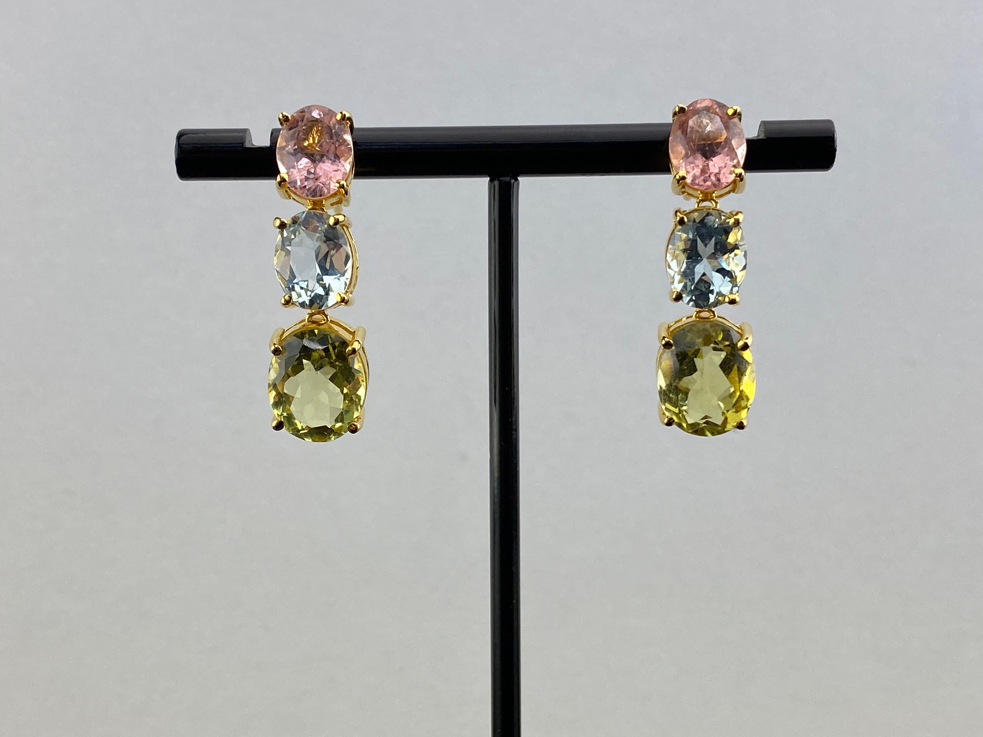 A stunning pair of oval shaped natural Tourmaline, Aquamarine and Quartz dangle earrings, weighing a total of 13.58 carats. The color combination oof pink, blue, and green make these dangle earrings very versatile - and being set in 18K Rose Gold,