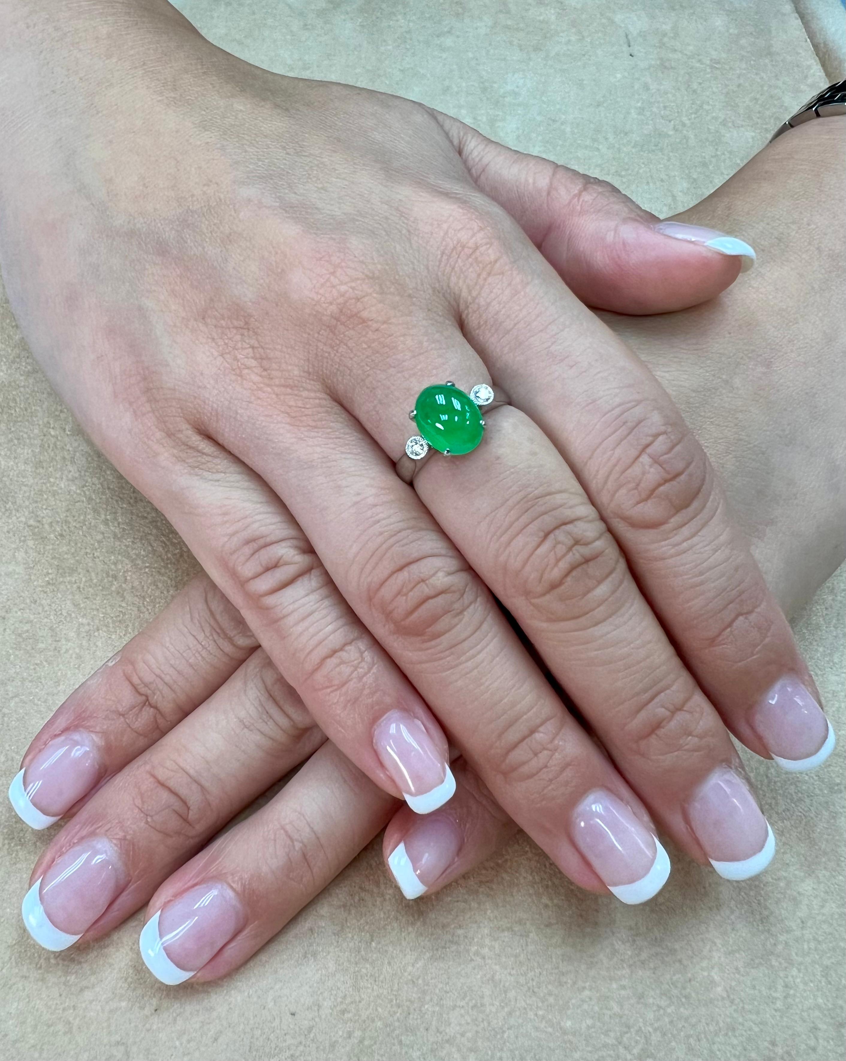 Please check out the HD Video! Here is an apple green Jade and diamond ring with super GLOW!. It is certified natural jadeite jade. The ring is set in 18k white gold and diamonds. There are 2 round brilliant diamonds that are on each side of the