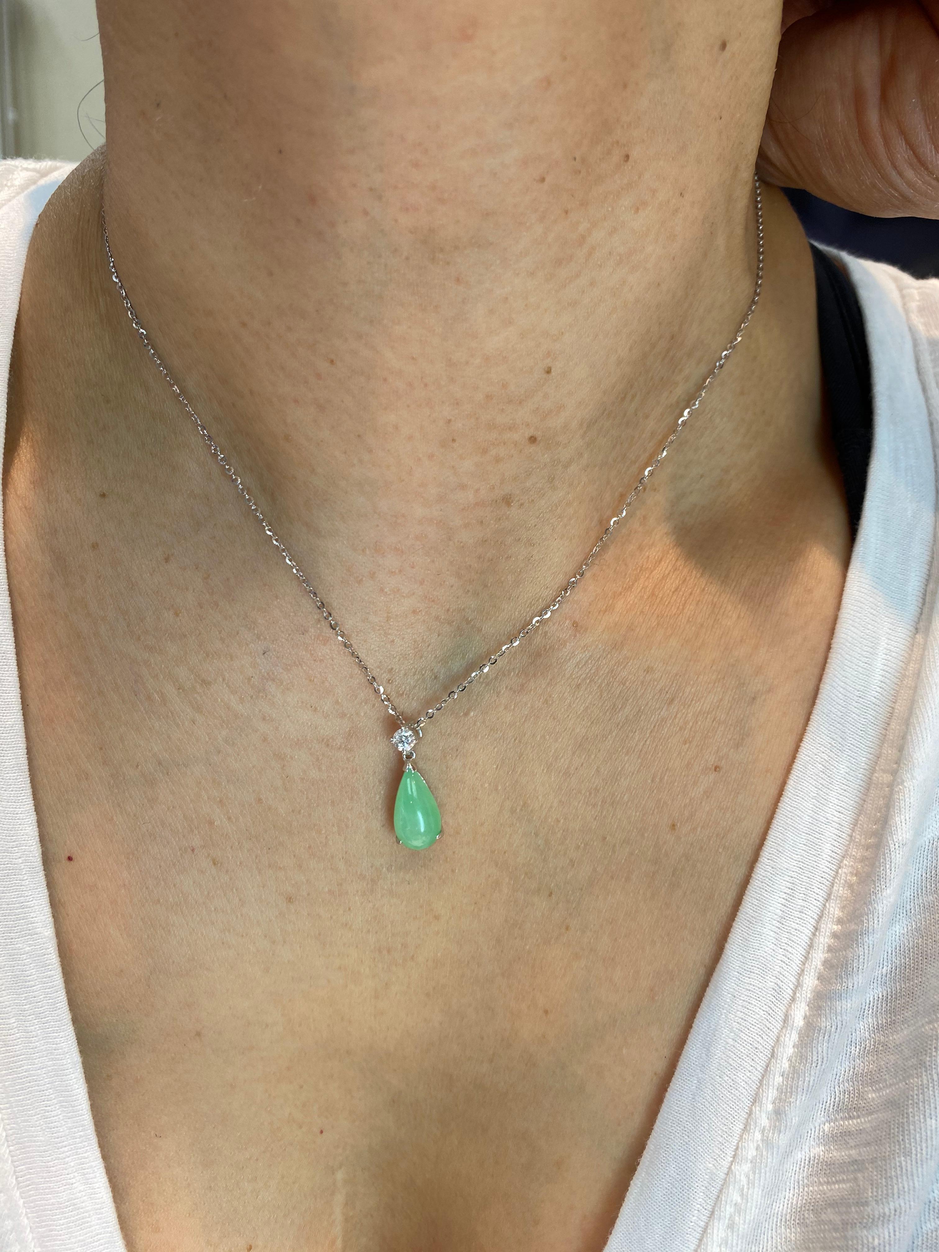Here is a natural light green Jade and diamond pendant. It is certified. The pendant is set in 18k white gold and diamonds. There is one diamond weighing 0.17 cts set on top of the pear-shaped cabochon (tear drop) green jade. The untreated /