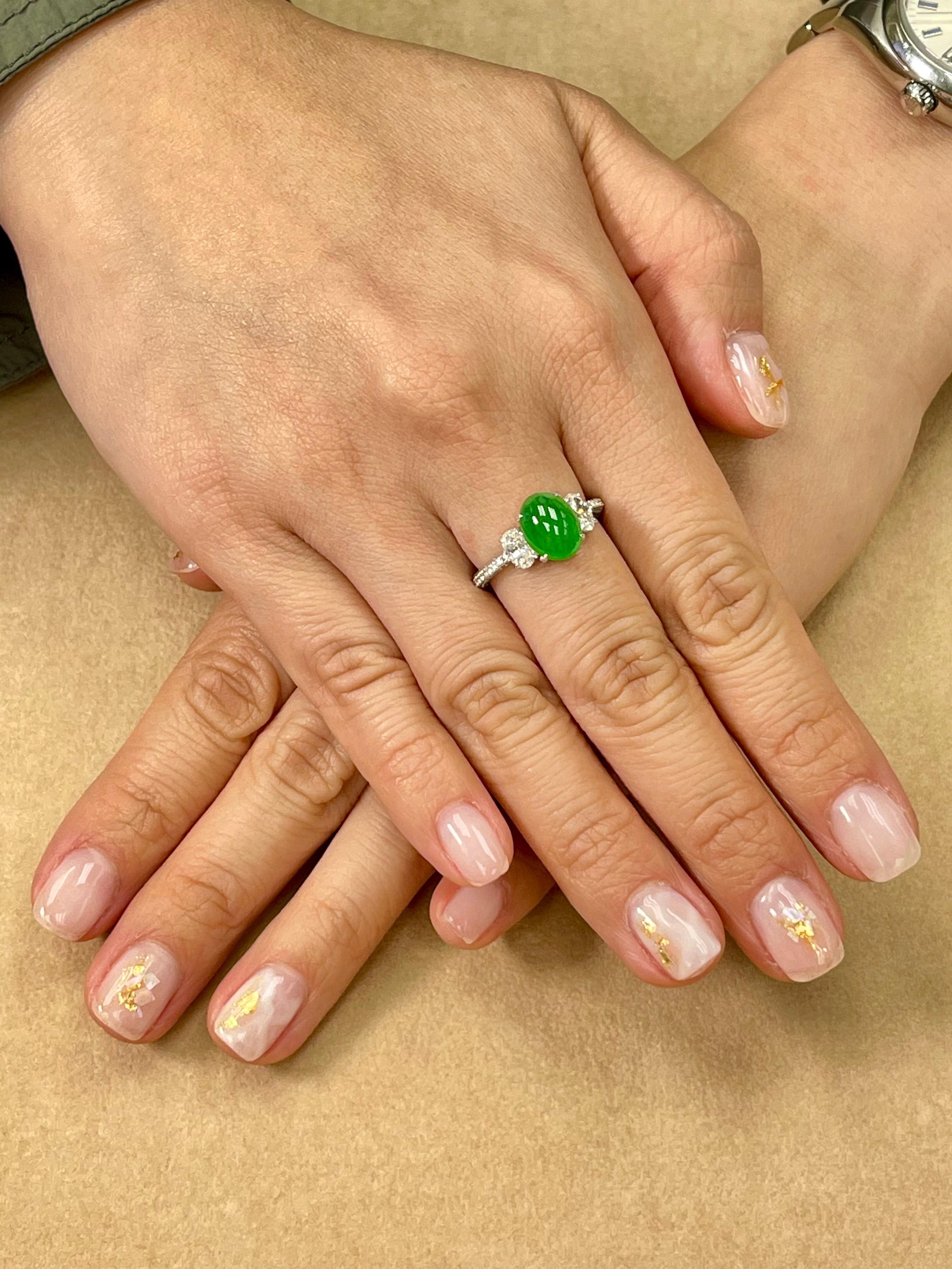 Please check out the HD Video! Here is an apple green Jade and diamond ring. It is certified natural jadeite jade. The ring is set in 18k white gold and diamonds. There are 2 Oval diamonds that are on each side of the jade center stone. Each oval