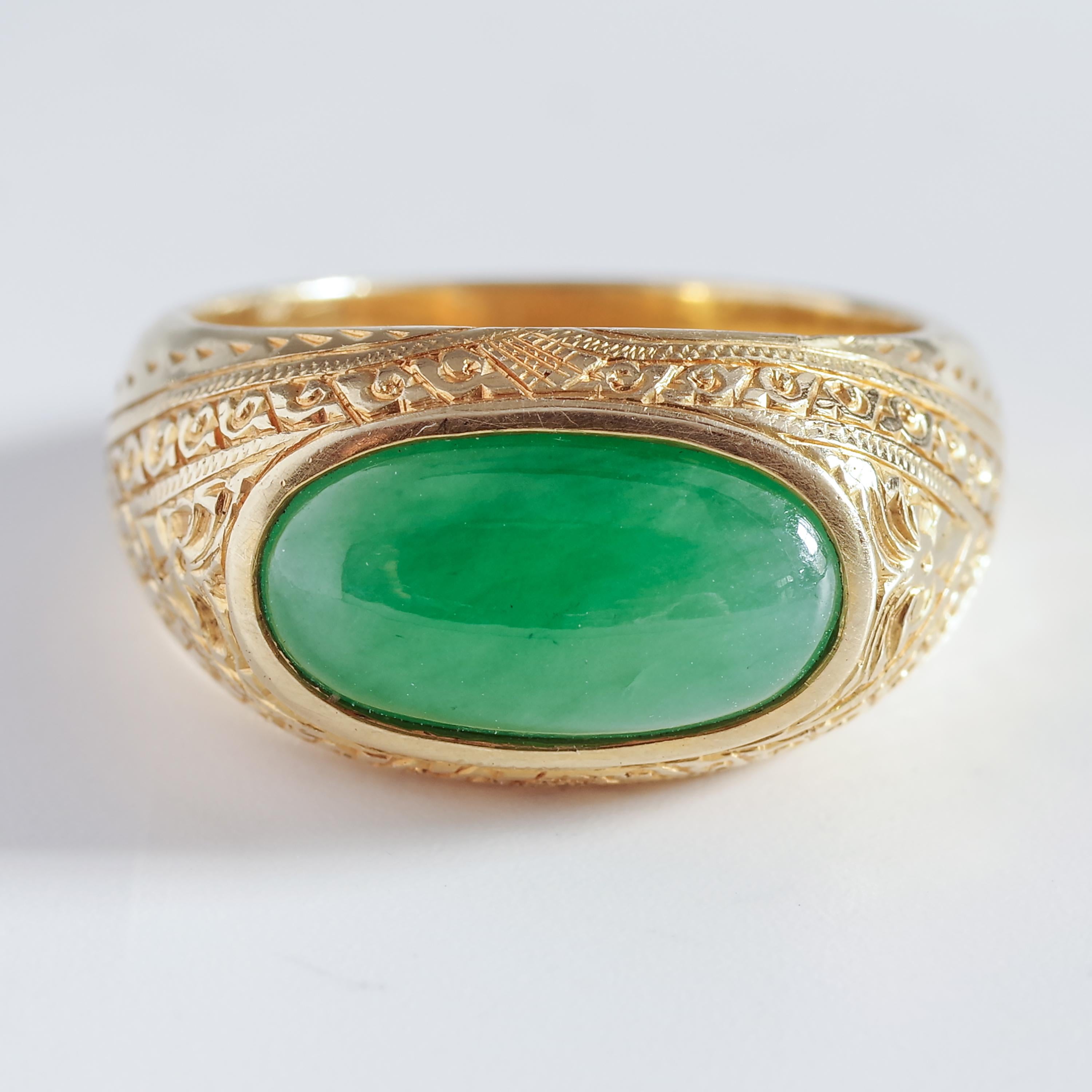 A luminous, hand-formed natural and untreated 15.5 mm x 8.6 mm Burmese jadeite jade cabochon in apple green is bezel-set within this satisfyingly weighty and solid rich yellow gold band that is unmarked but tests higher than 18-karat (though I'm