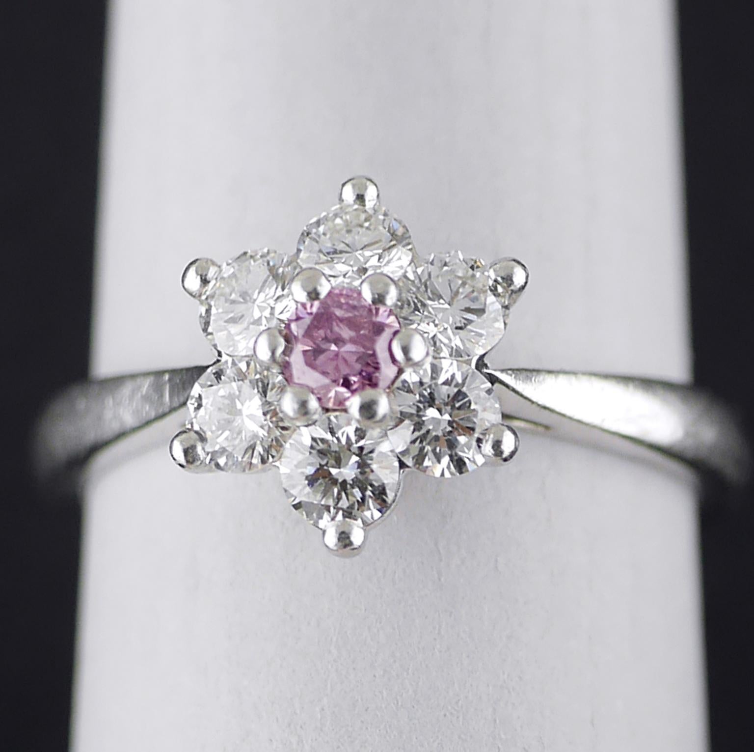 Certified natural colour fancy purple round brilliant cut and white diamond cluster ring, 2010.

0.13ct Brilliant cut central diamond, light purple colour with a pinkish hue, surrounded by 6 white diamonds (0.60ct, F/G, Vs1 approx) set in a Platinum