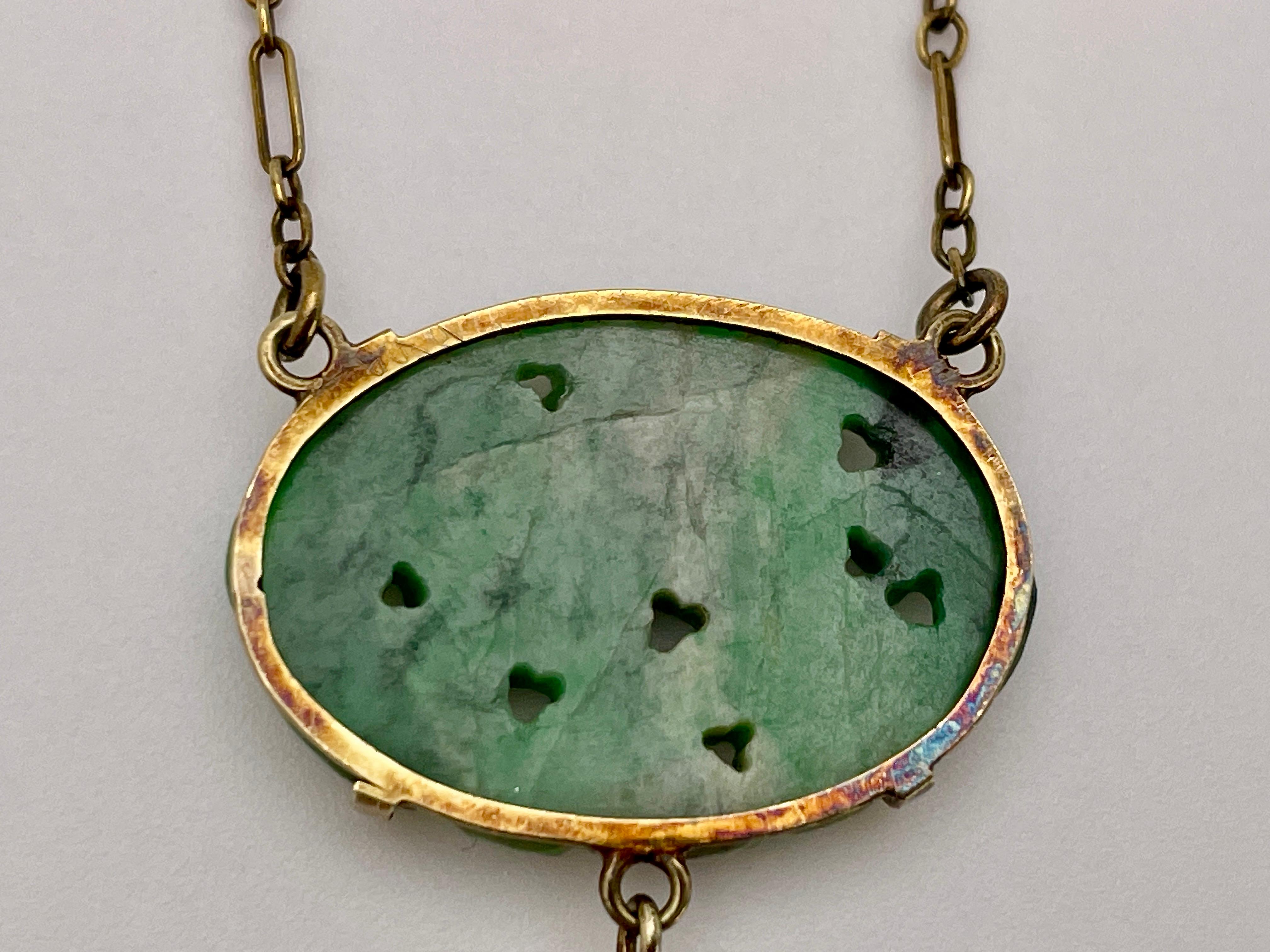 An original Victorian 14K yellow gold certified natural jade pendant. Centered with one oval carved and pierced cabochon-cut natural jade omphacite, measuring approximately 21.50 x 15.50 x 3.00 MM, weighing approximately 9.00 CT, and colored mottled