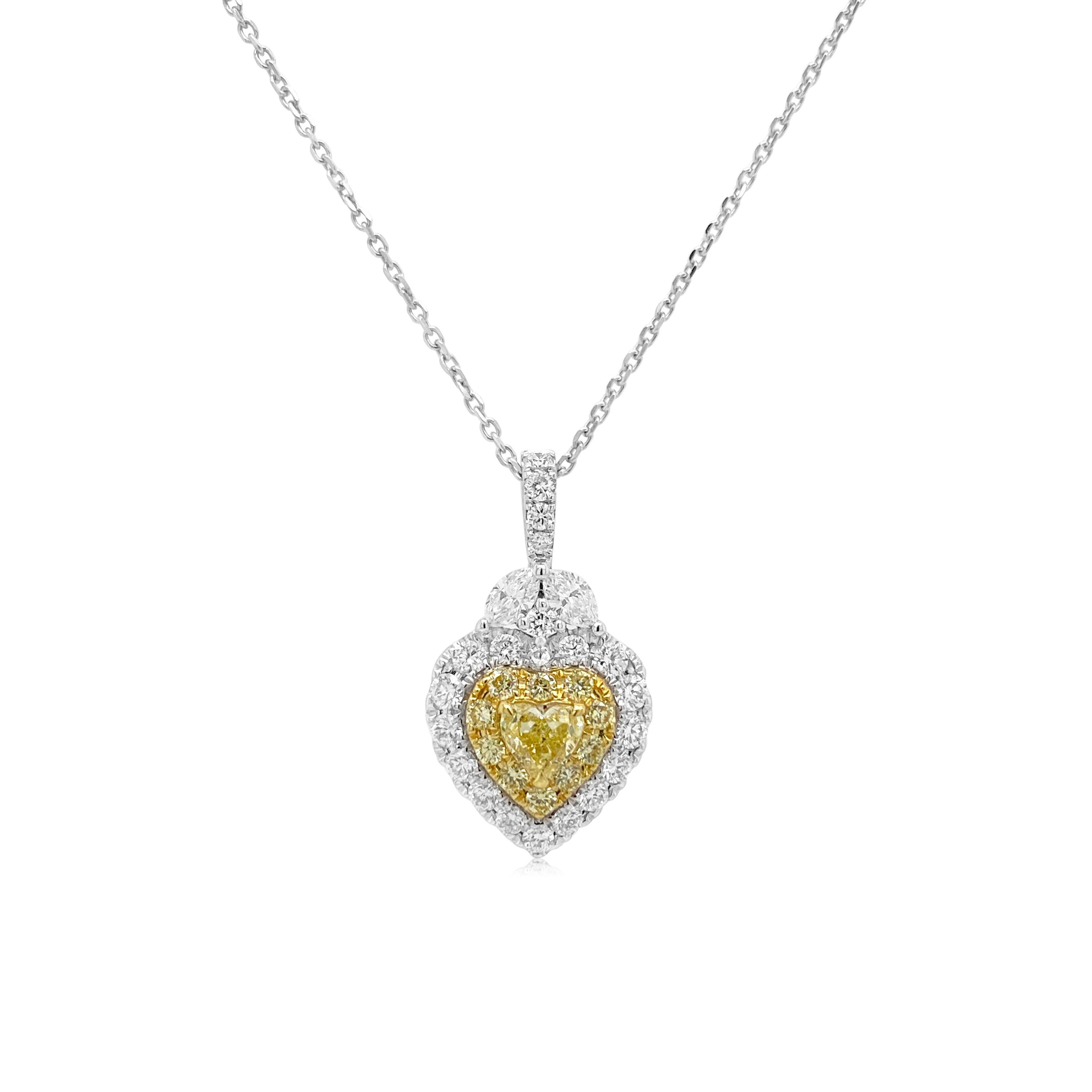 This charming yellow diamond pendant is set in white and yellow gold surrounded with round brilliant cut yellow and white diamonds. Heart shaped Yellow diamonds are rare and known to attract happiness and prosperity. An elegant addition to your fine