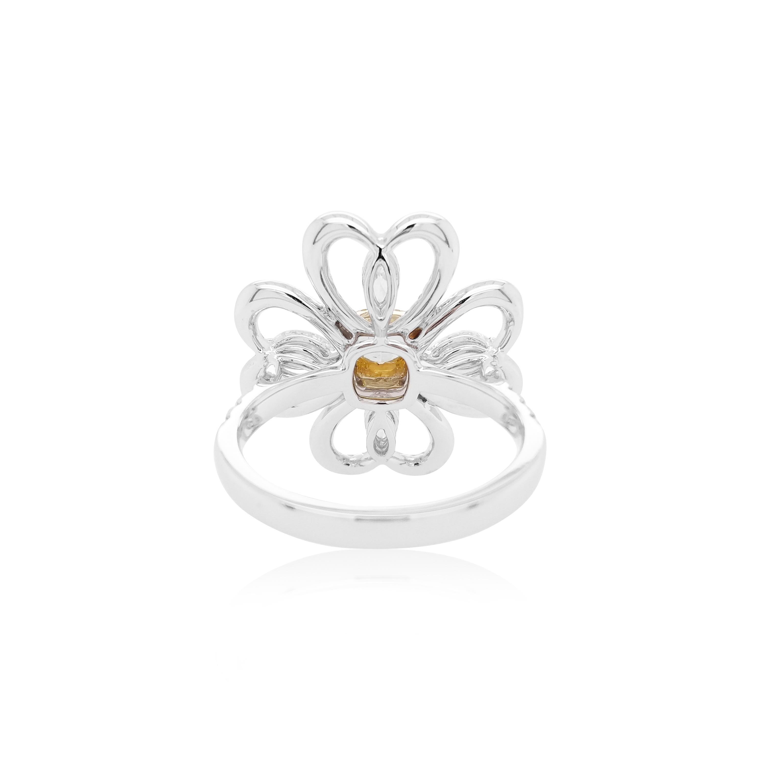 This contemporary 18K Gold ring features a natural Yellow Diamond set at its centre, with a halo of round brilliant-cut yellow diamonds. They are perfectly accentuated by the white diamond floral motif which surrounds it. Unique and striking, this