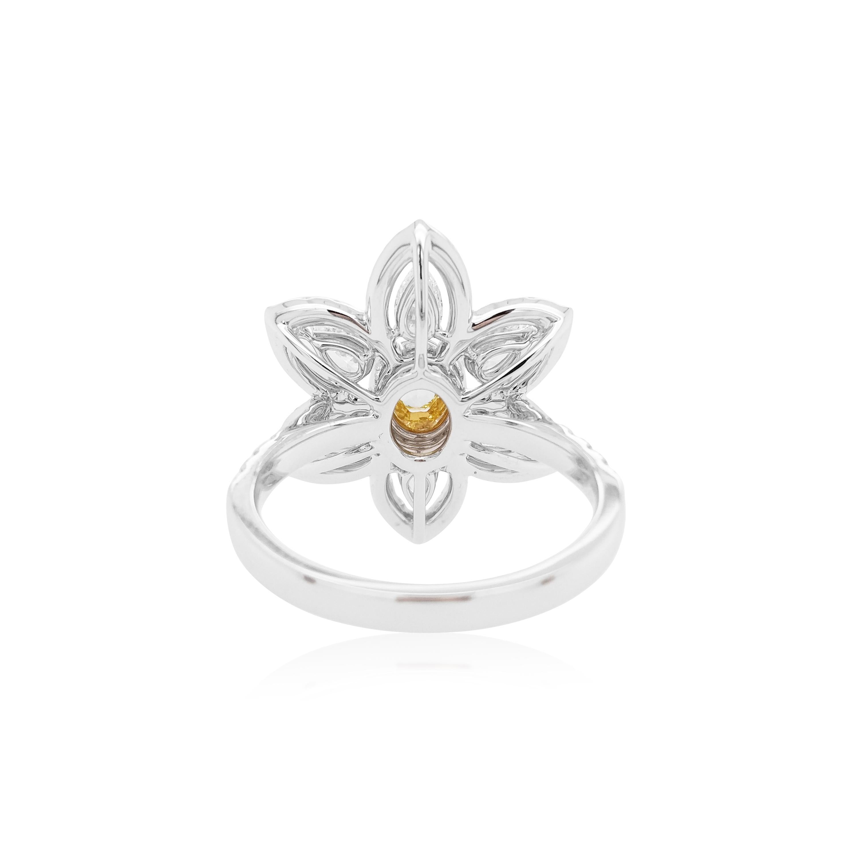 This contemporary 18K Gold ring features a natural Yellow Diamond set at its centre, with a halo of round-shape yellow diamonds. They are perfectly accentuated by the pear-shape and round-shape white diamonds as a floral motif which surrounds it.