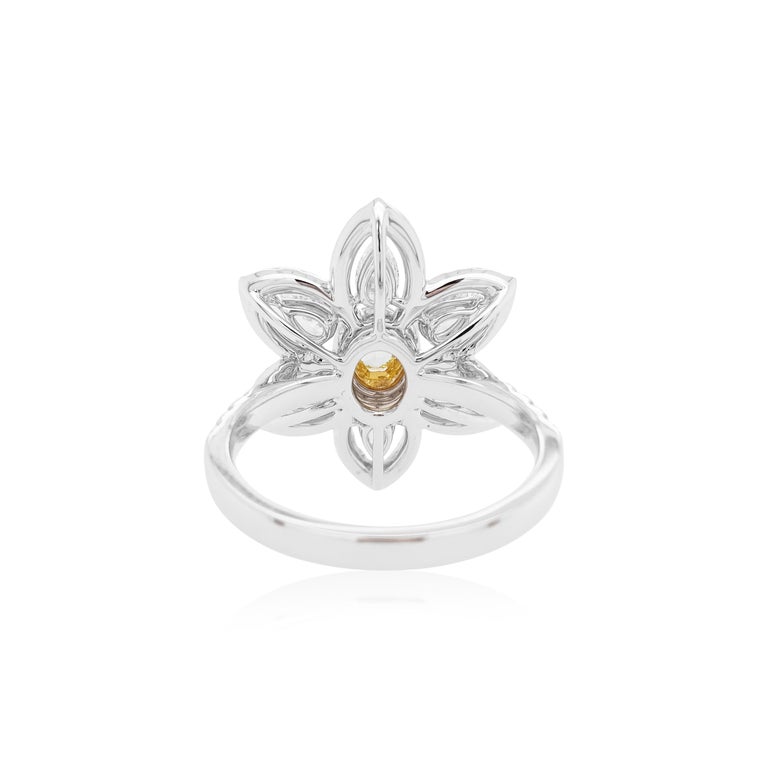 This contemporary 18K Gold ring features a natural Yellow Diamond set at its centre, with a halo of round-shape yellow diamonds. They are perfectly accentuated by the pear-shape and round-shape white diamonds as a floral motif which surrounds it.