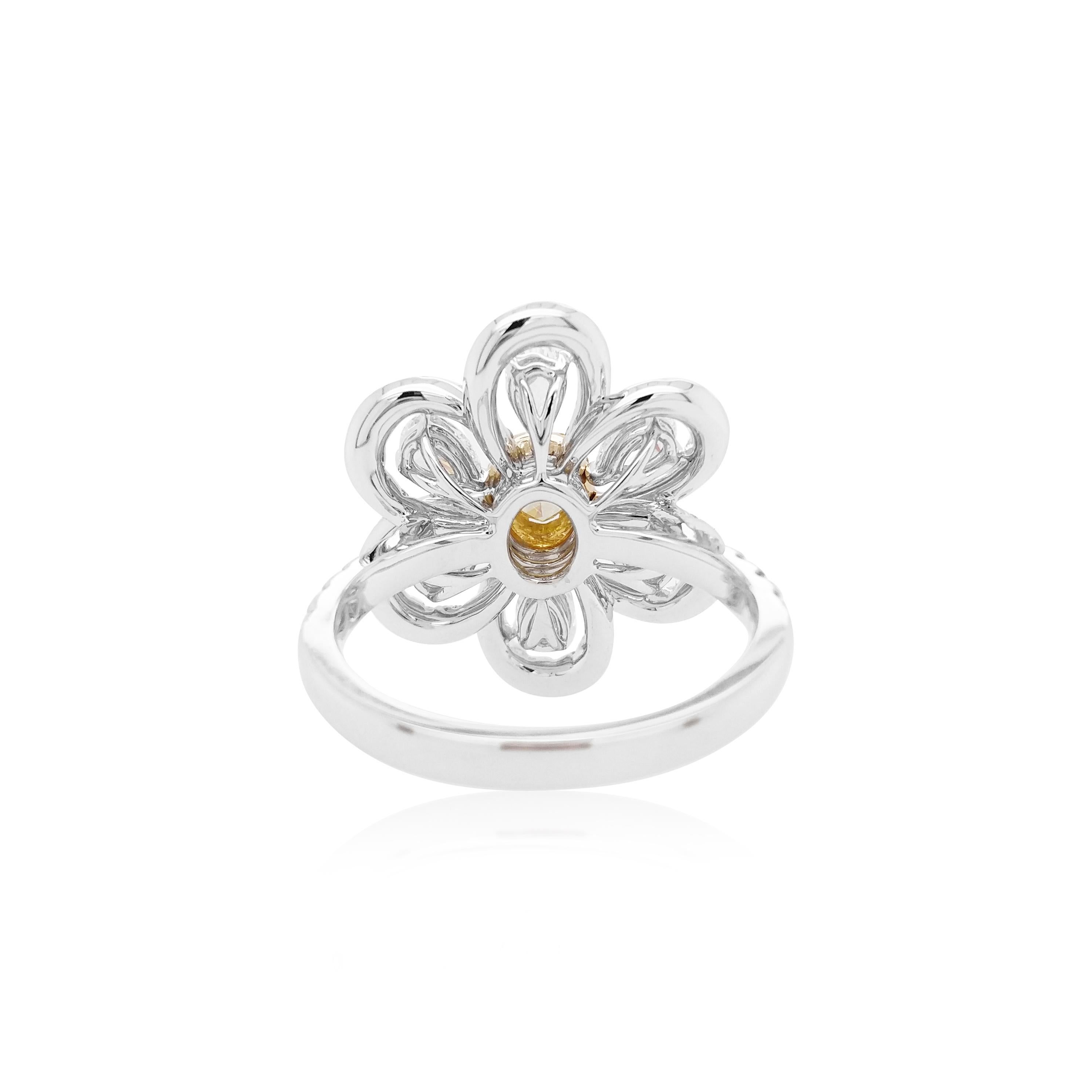 This unique flower-shaped ring features a natural oval-shape Yellow diamond at the heart of their design. The rich colour of these diamonds is complimented perfectly by the delicate 18 Karat white gold and yellow gold floral design which completed
