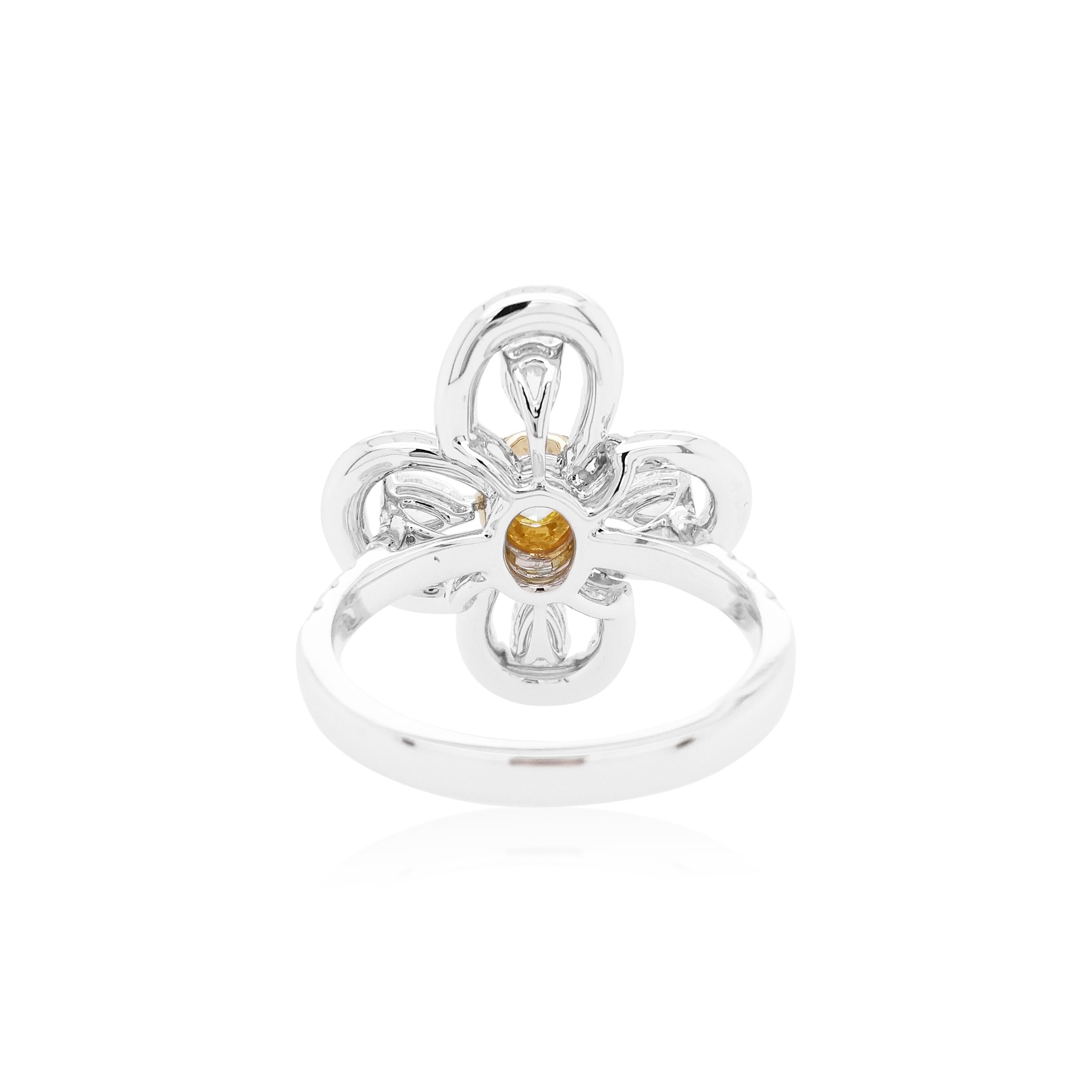 This timeless 18K gold ring features a lustrous Yellow diamond surrounded by small Yellow diamonds as a halo, and delicate arrangement of pear shape and round shape white diamonds. This ring is a contemporary classic and will make the perfect