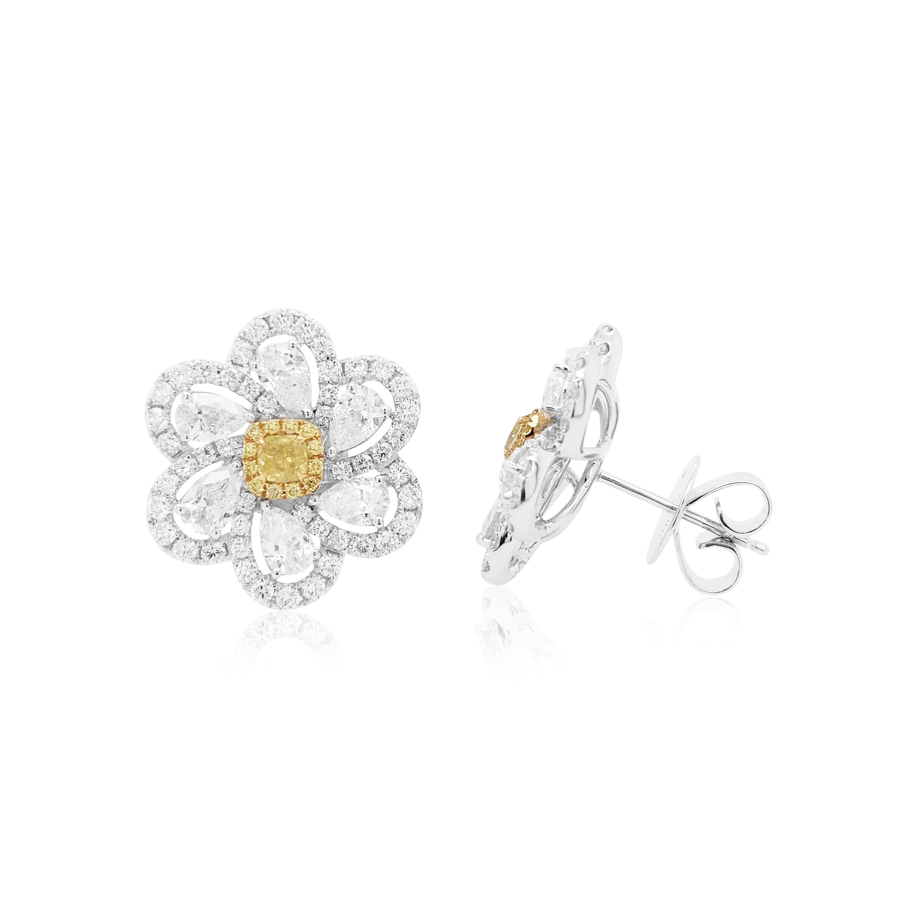 These unique flower shaped earrings feature natural Cushion-shape Yellow diamonds at the heart of their design. The rich colour of these diamonds is complimented perfectly by the delicate 18 Karat white gold floral design which completed by a