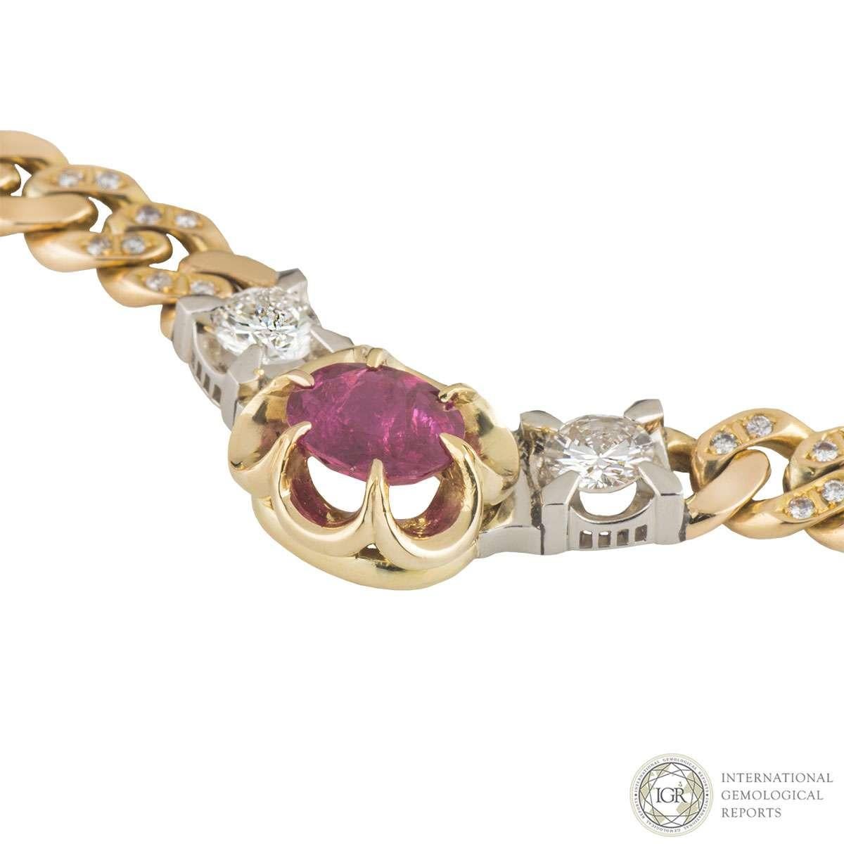 An 18k yellow gold ruby and diamond necklace. The necklace features an oval mixed cut natural ruby weighing approximately 2.40ct, displaying a bright medium pinkish red colour. Set to either side of the ruby there is a single round brilliant cut