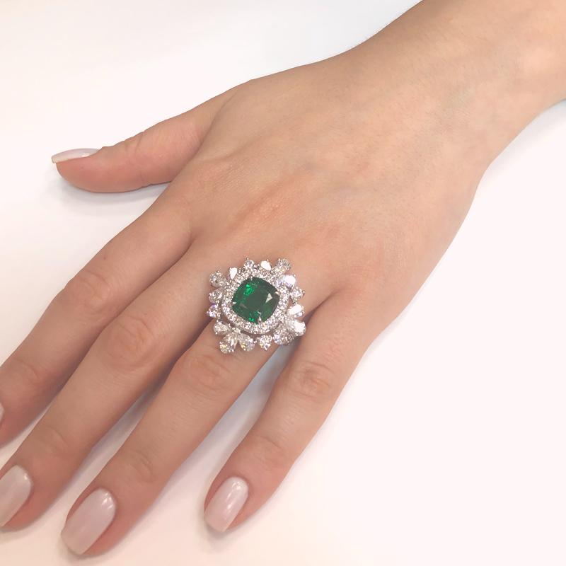 This brilliant sunburst style ring is crowned with a green emerald cut emerald 4.65 carat stone from Zambia.
Accented by round and pear diamonds 5.18 carat total. 
Diamonds are white and natural and in G-H Color Clarity VS.
A gorgeous Art Deco