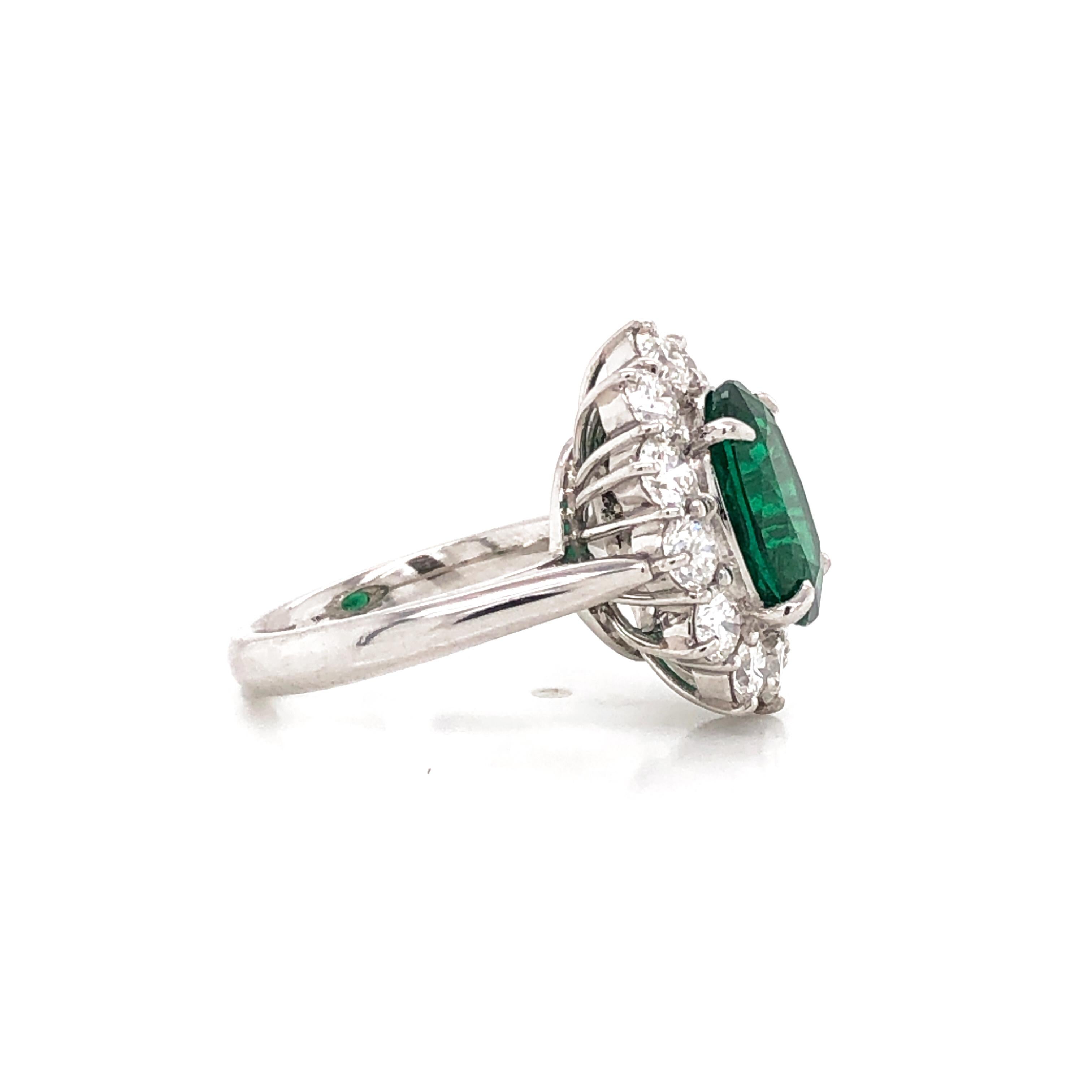 Elegantly styled oval cut green Zambian emerald 3.22 carat center stone.  C. Dunaigre Switzerland Certified emerald. Minor oil treated. Accented by round diamonds 2.03 carat in total.  Diamonds are white and natural and in G-H Color Clarity VS.