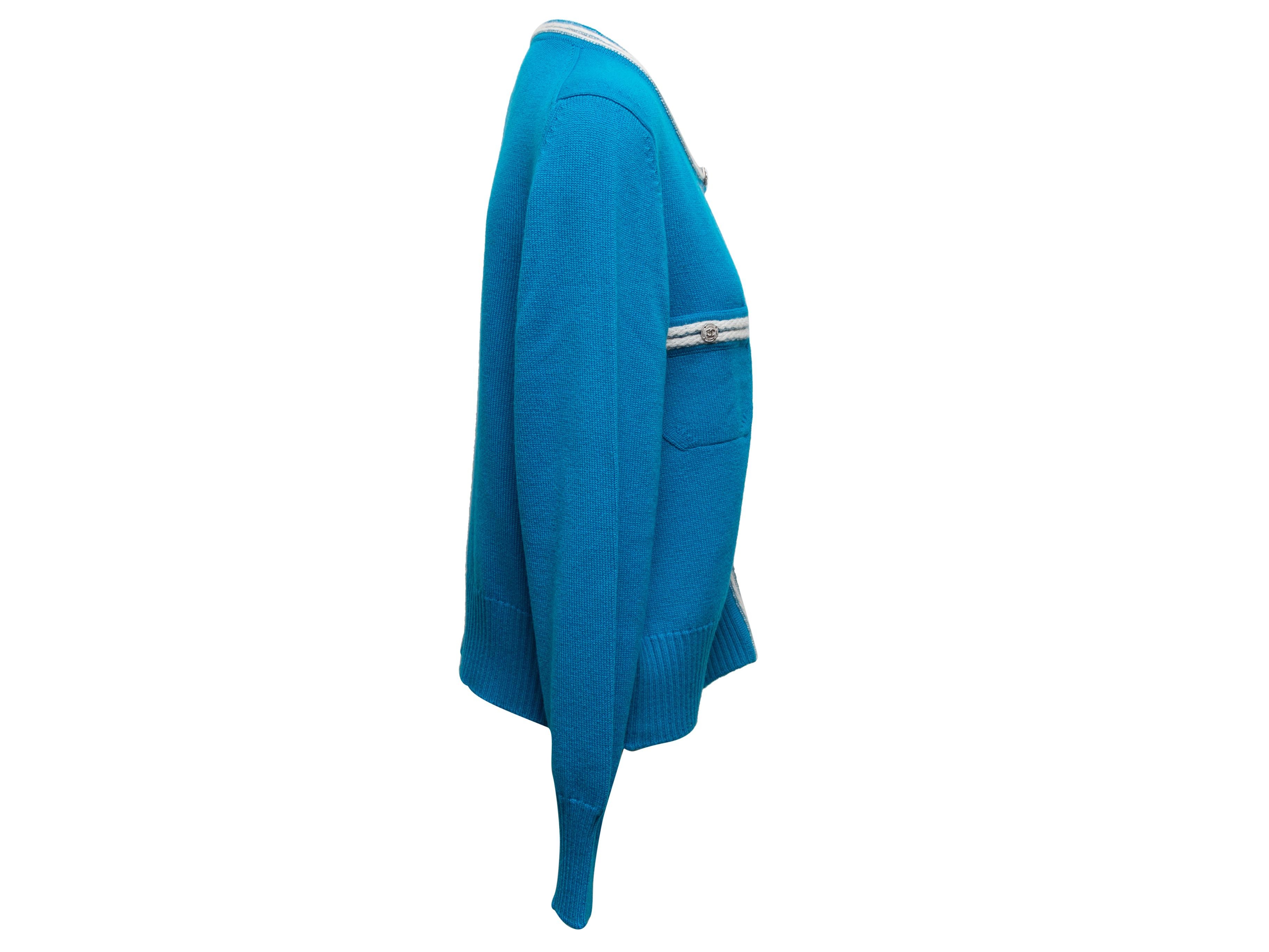 Cerulean and white cashmere cardigan by Chanel. Crew neck. Dual bust pockets. Button closures at center front. 46