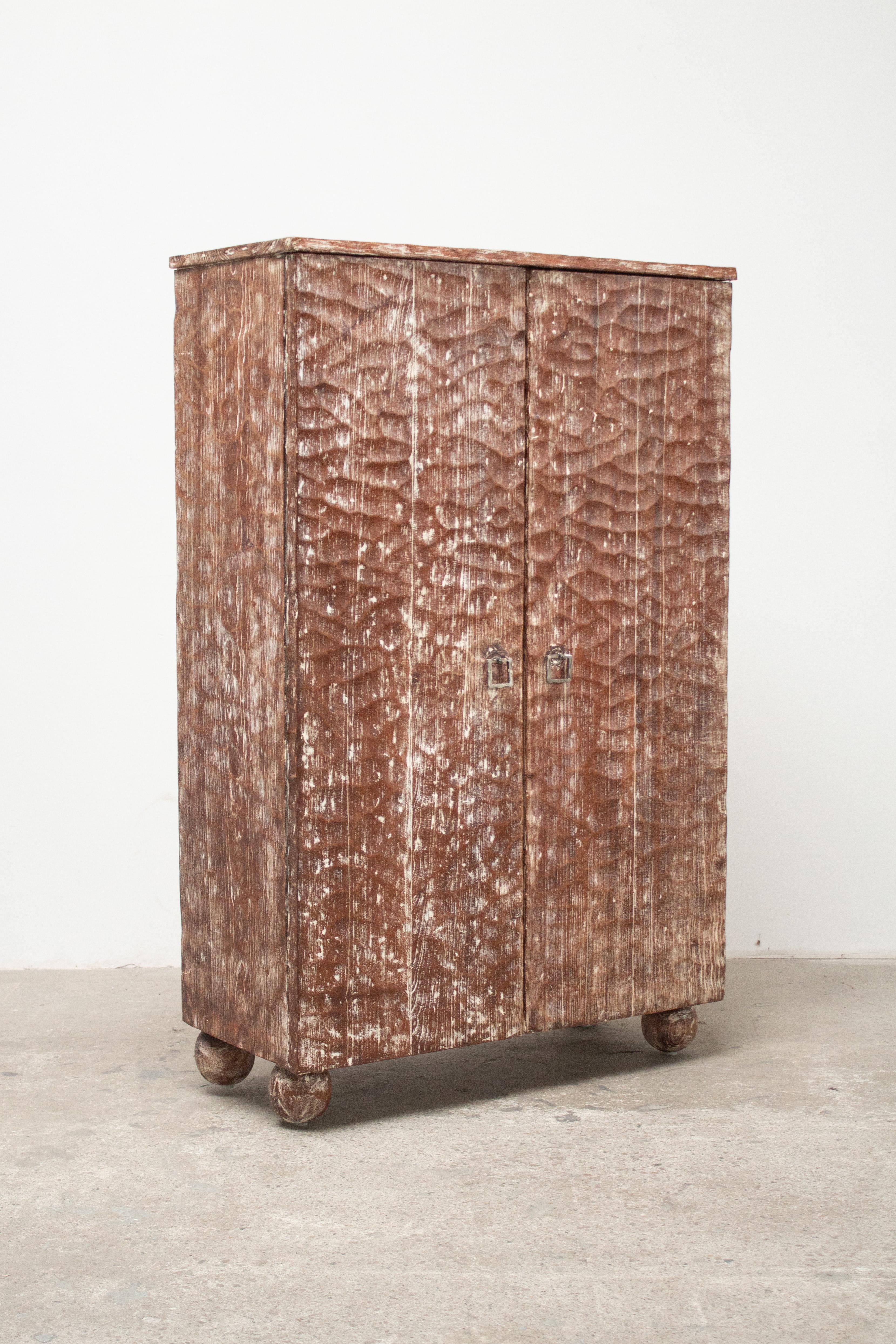 A French gouged oak cabinet circa 1940s. Warm wood tone with white washed cerused finish and forged iron hardware. Ball feet. Six interior cupboards. In the style of Jean-Michel Frank's gauge carved pieces. Sourced in France.