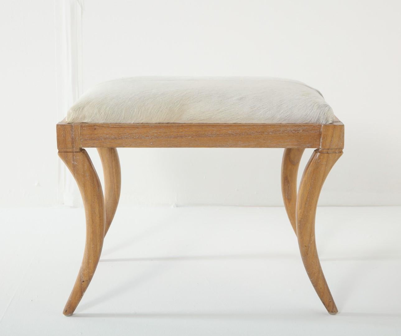 Cerused oak saber-leg ottoman with white pony hide seat, in the style of Jean-Michel Frank.