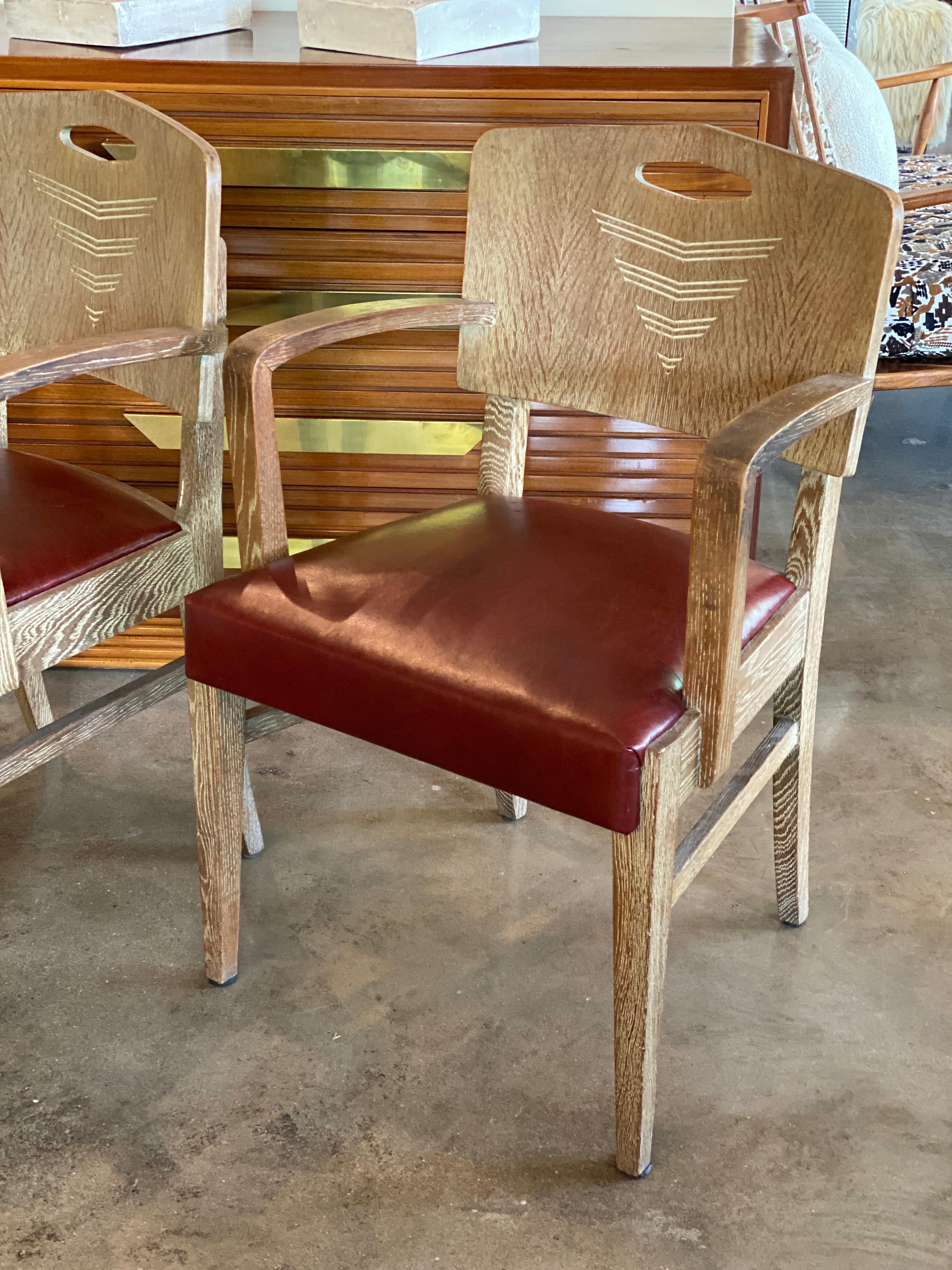 Paire de chaises Art déco en finition cérusée sur chêne, conçues par le célèbre architecte suisse Michel Polak. Sièges nouvellement rembourrés en cuir rouge sang de boeuf/marron. Les chaises sont probablement une fabrication ancienne de Joseph de