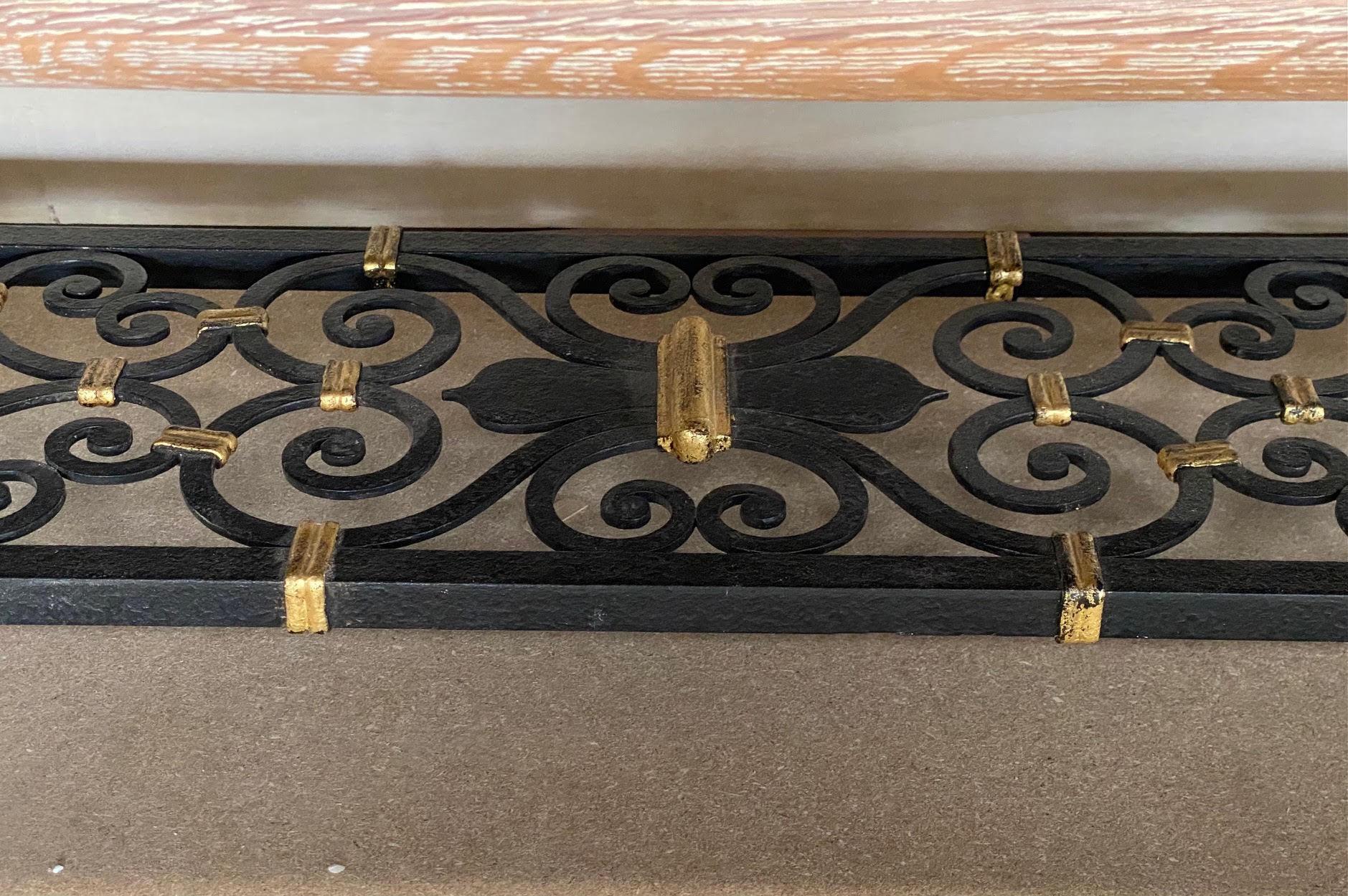 Impressive credenza made of cerused oak sculpted on the sides and base.
The bottom features a wrought iron shelf with a brass connection and the door fronts are covered with leather decorated with iron and brass cabochons. 
A very sophisticated