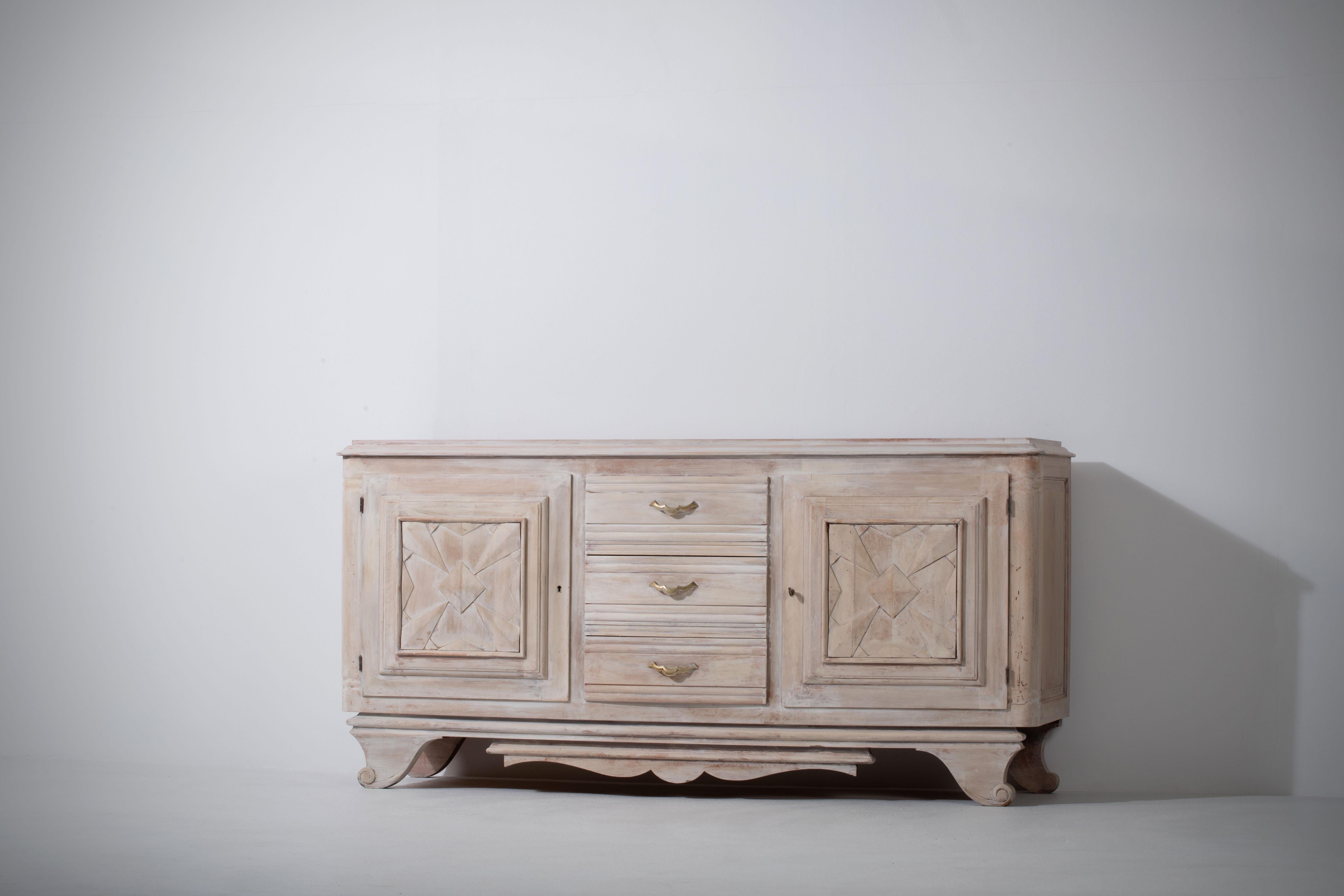 Large credenza, solid oak, France, 1940s.
Large Art Deco Brutalist sideboard. 
The credenza consists of two laterals storage facilities and covered with very detailed designed doors, in the center, a top drawer and a drink cabinet.
The refined