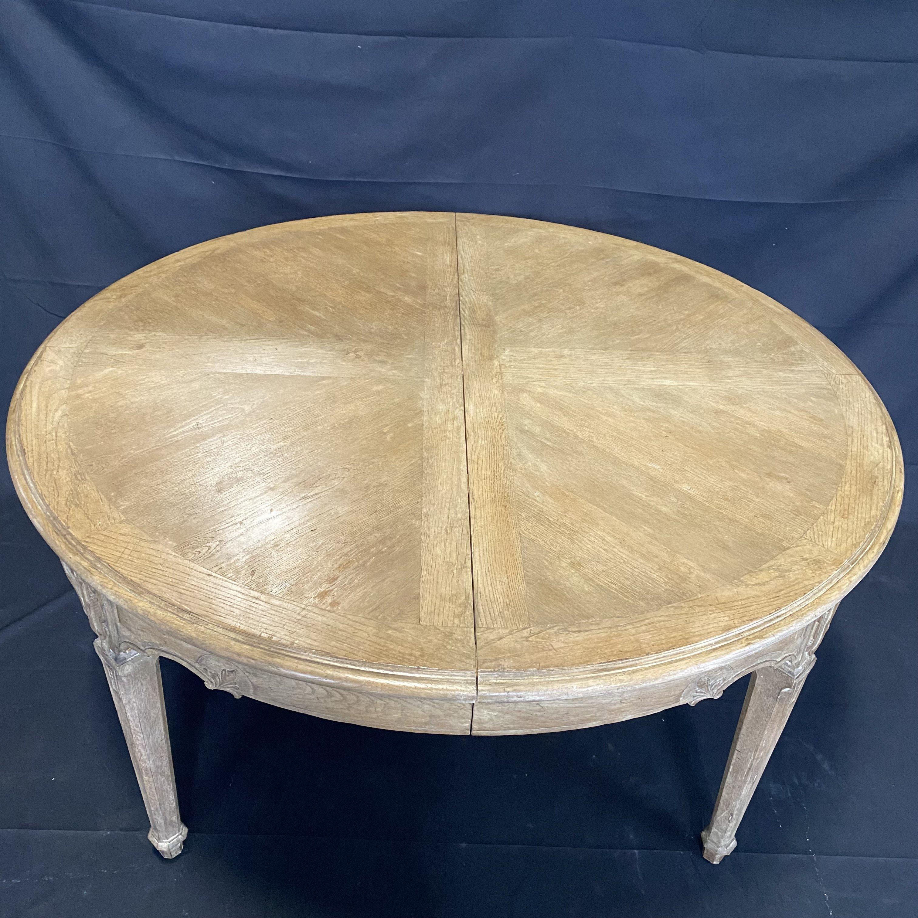 Beautiful French cerused oak dining table by the furniture designer Erik Bolin. Versatile round or oval table with one large leaf, extending from 60.5