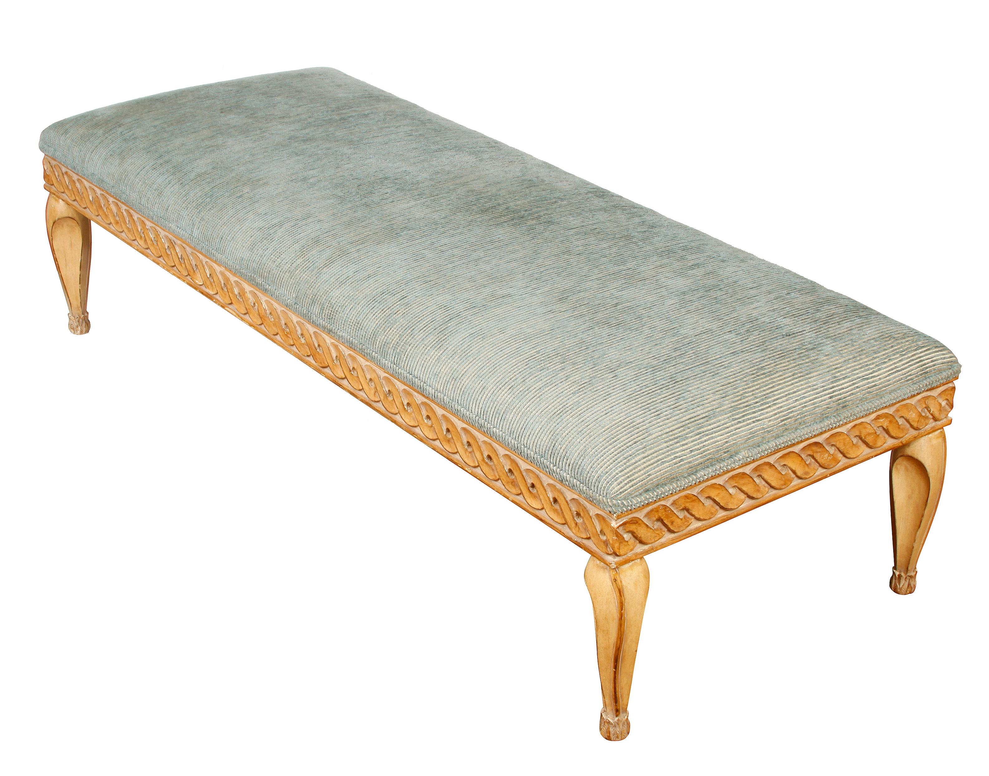 Cerused oak carved wood ottoman with rope trim to the skirt and sculptured legs with capped feet. Ottoman is upholstered in pale blue textured stripe fabric.
