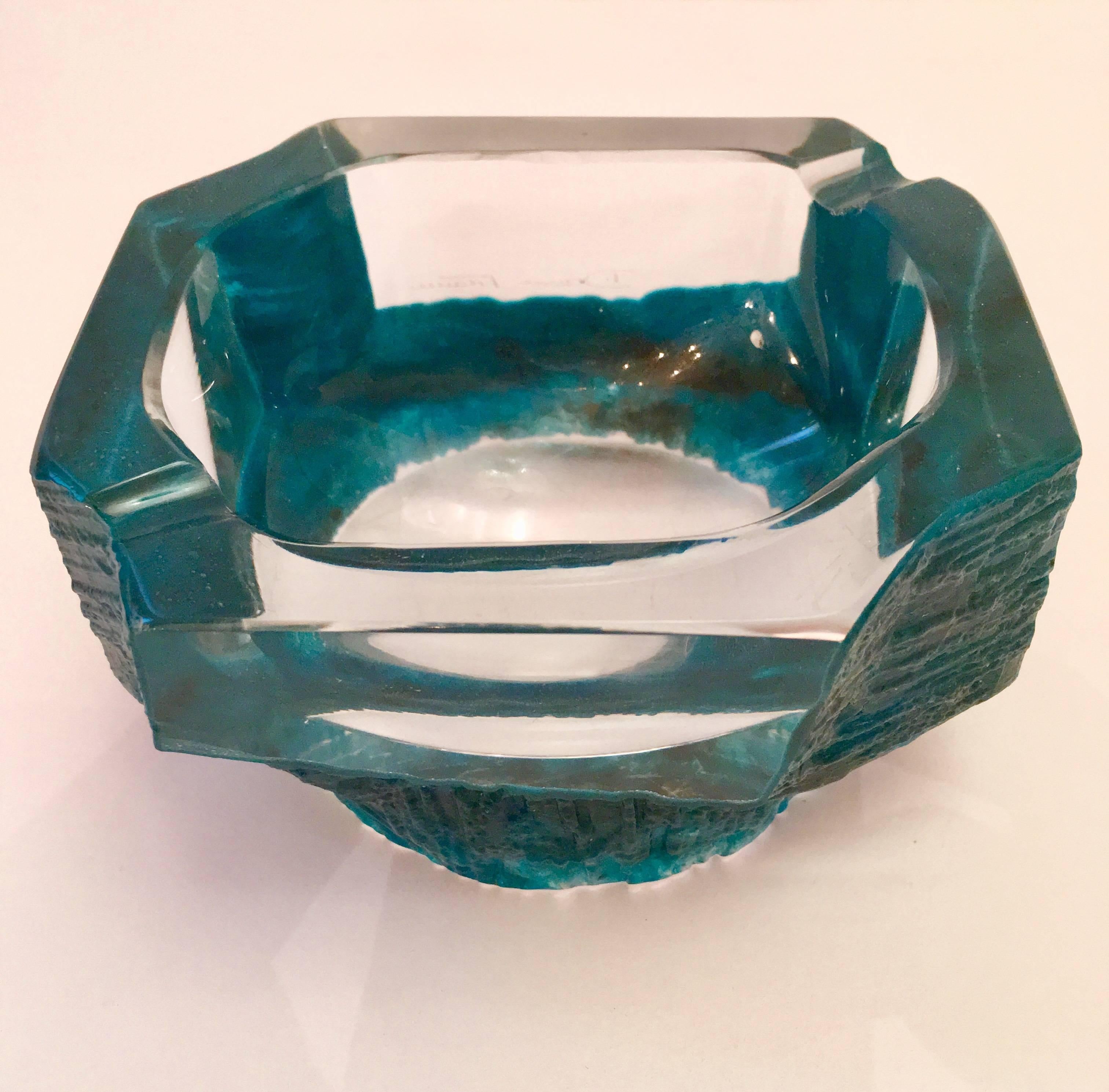 A turquoise and clear solid, heavy crystal bowl designed by the French artist, Cesar Baldaccini. Signed. Could be used for decoration, a candy or trinket dish, or ashtray.