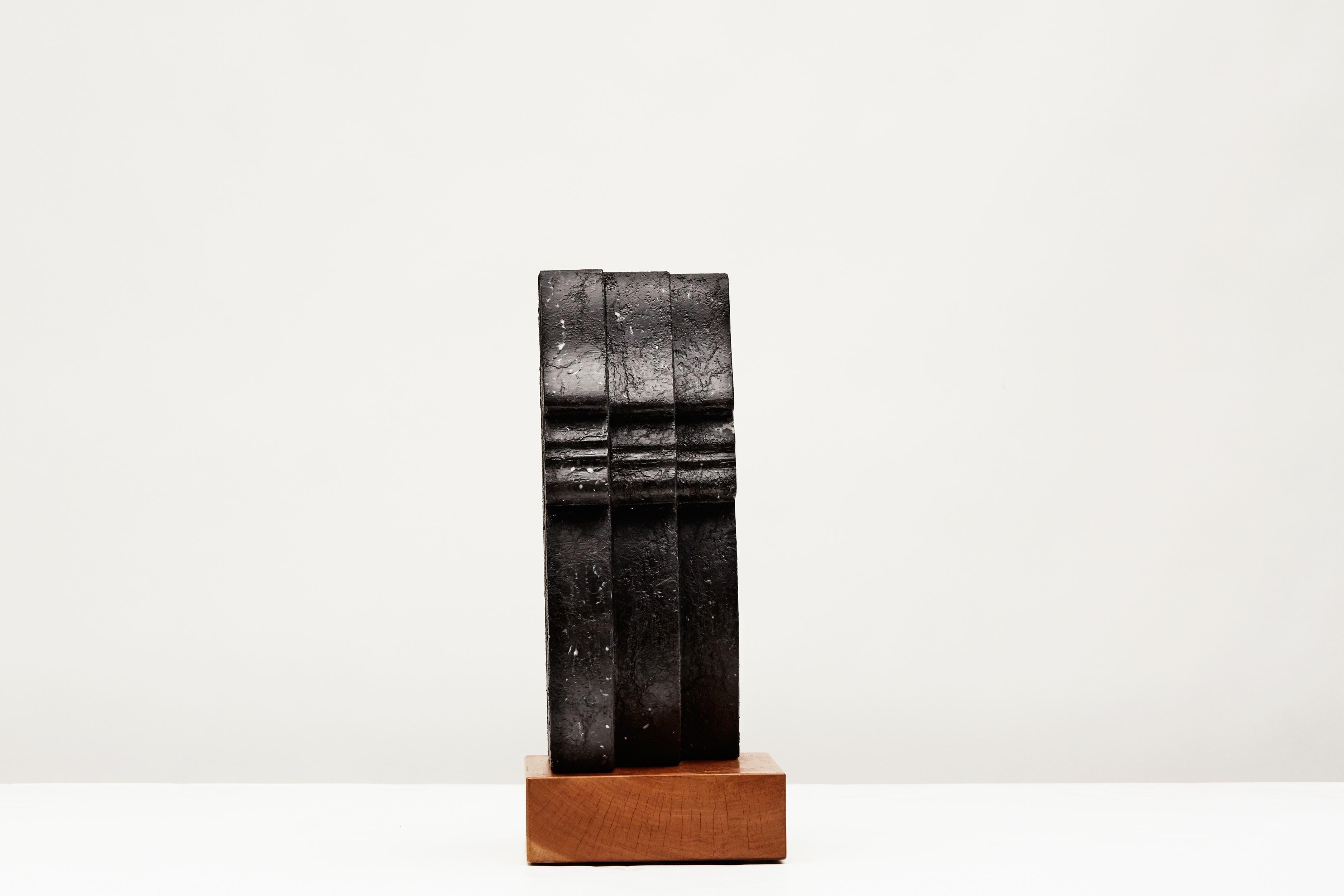 Inscribed: CLF 
Unique piece.

A Nero Marquina marble sculpture depicting a succession of three identical faces in profile.