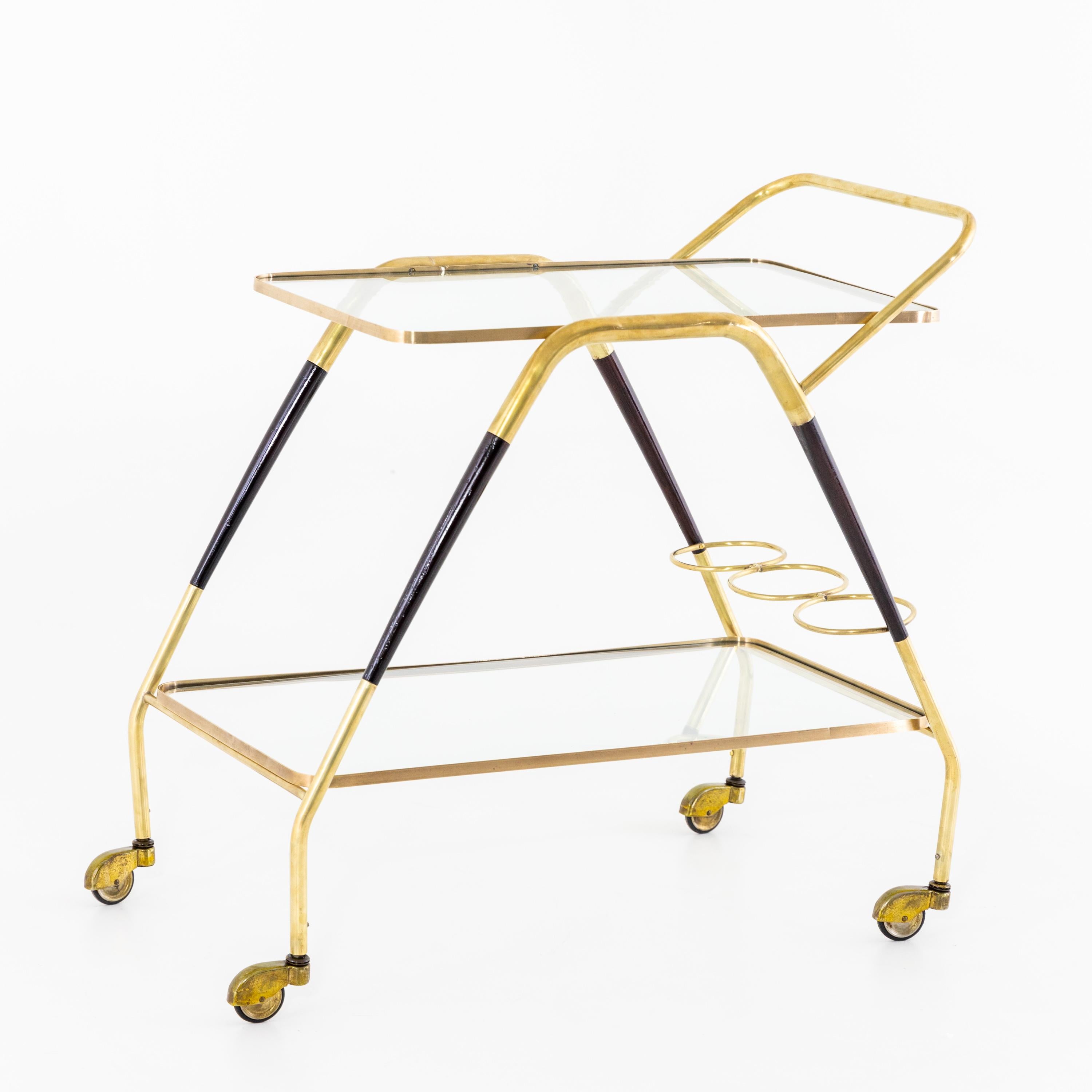 Bar cart on castors made of brass and glass with a bottle holder and two tiers.