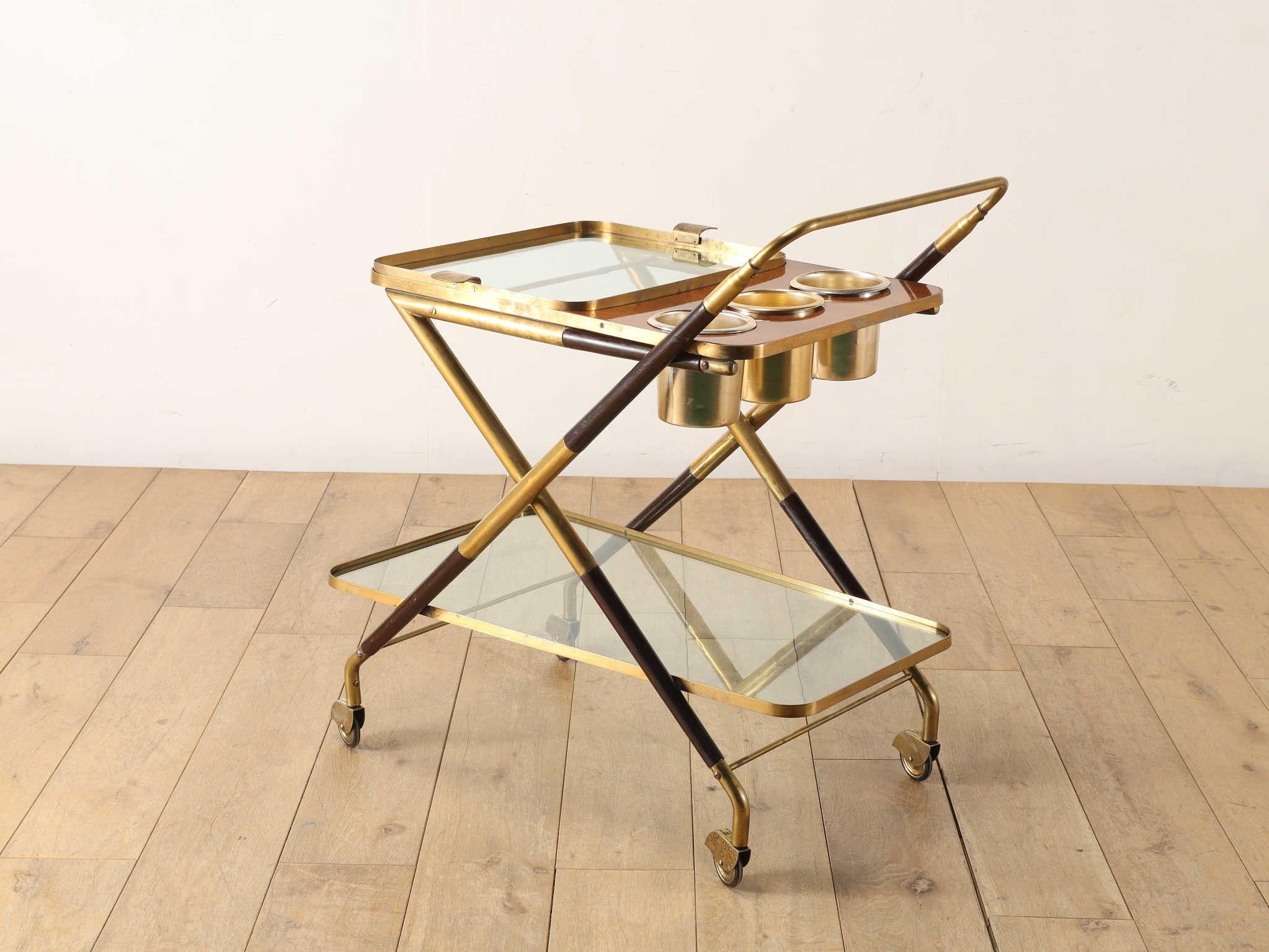 This vintage tea cart by Cesare Lacca is a masterful fusion of natural warmth and refined elegance, featuring a beautifully crafted frame made of wood and brass. The organic texture of the wood brings a sense of familiarity and comfort, while the