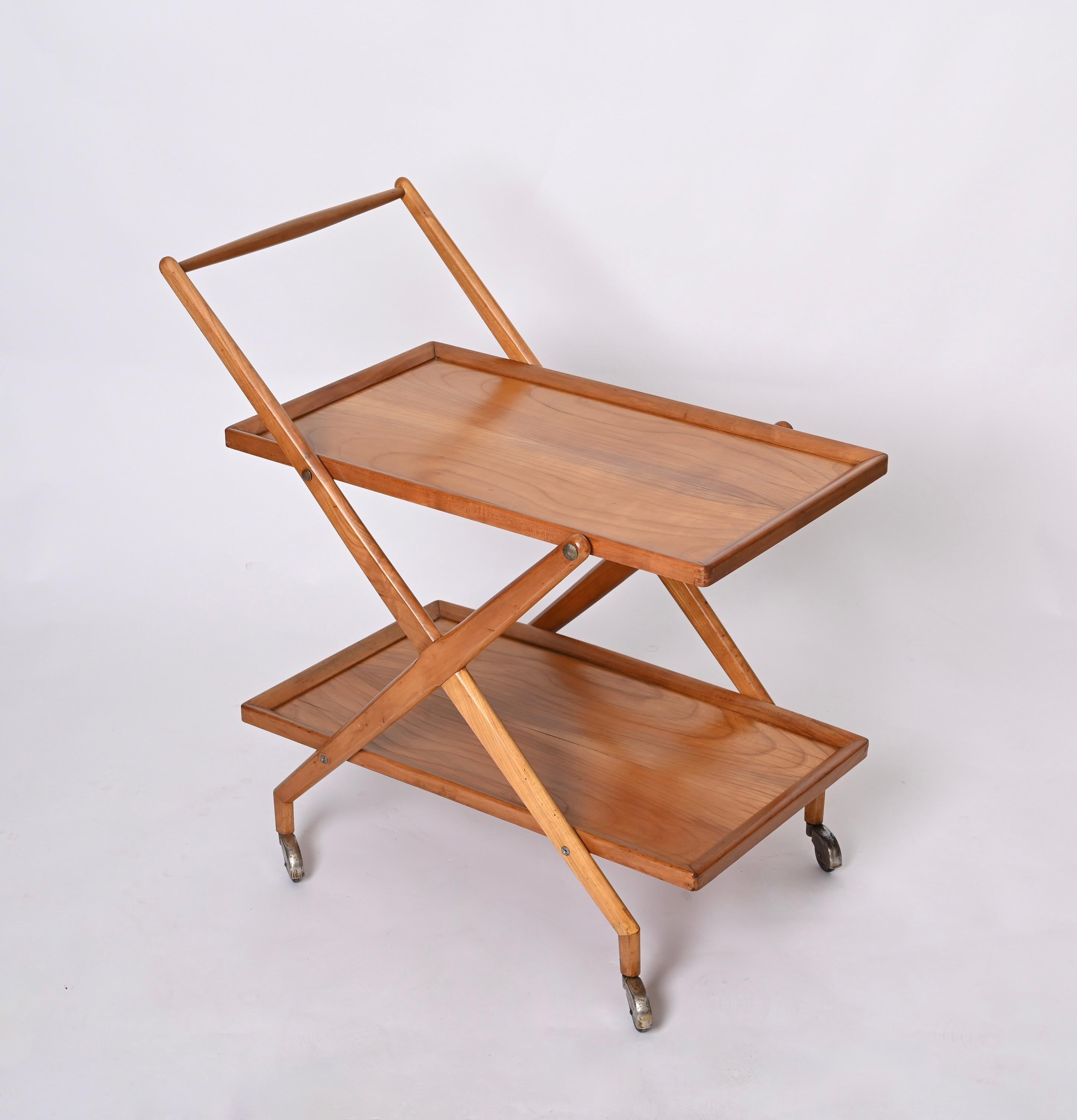 Fantastic midcentury Italian serving bar cart in cherry wood, with metal finishes. This cart was designed in Italy by Cesare Lacca during the 1950s.

This elegant piece has two shelves, fully made in solid cherry wood with stunning wood grains.
