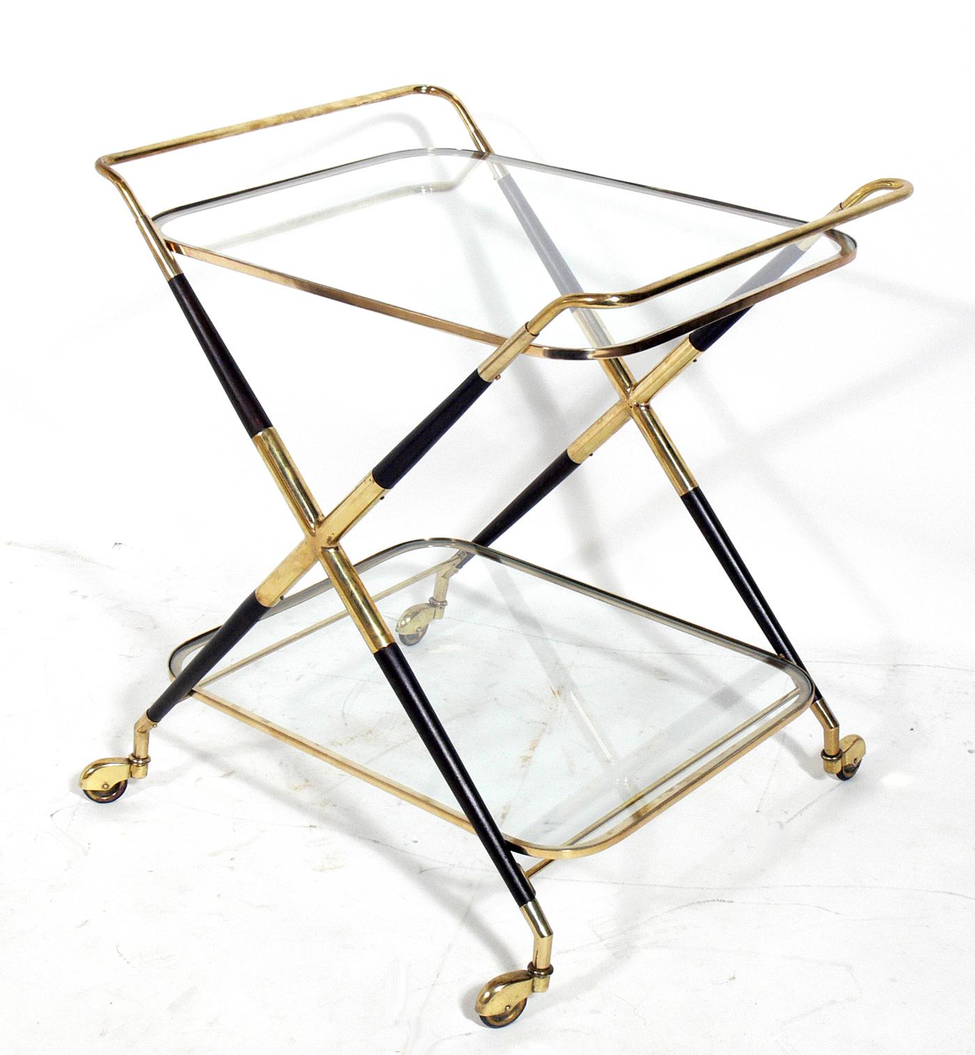 Sculptural Italian bar cart, designed by Cesare Lacca, Italy, circa 1950s. This example has been completely restored, with the wood being refinished in an ultra-deep brown lacquer, the brass being hand polished and lacquered, and the glass replaced.